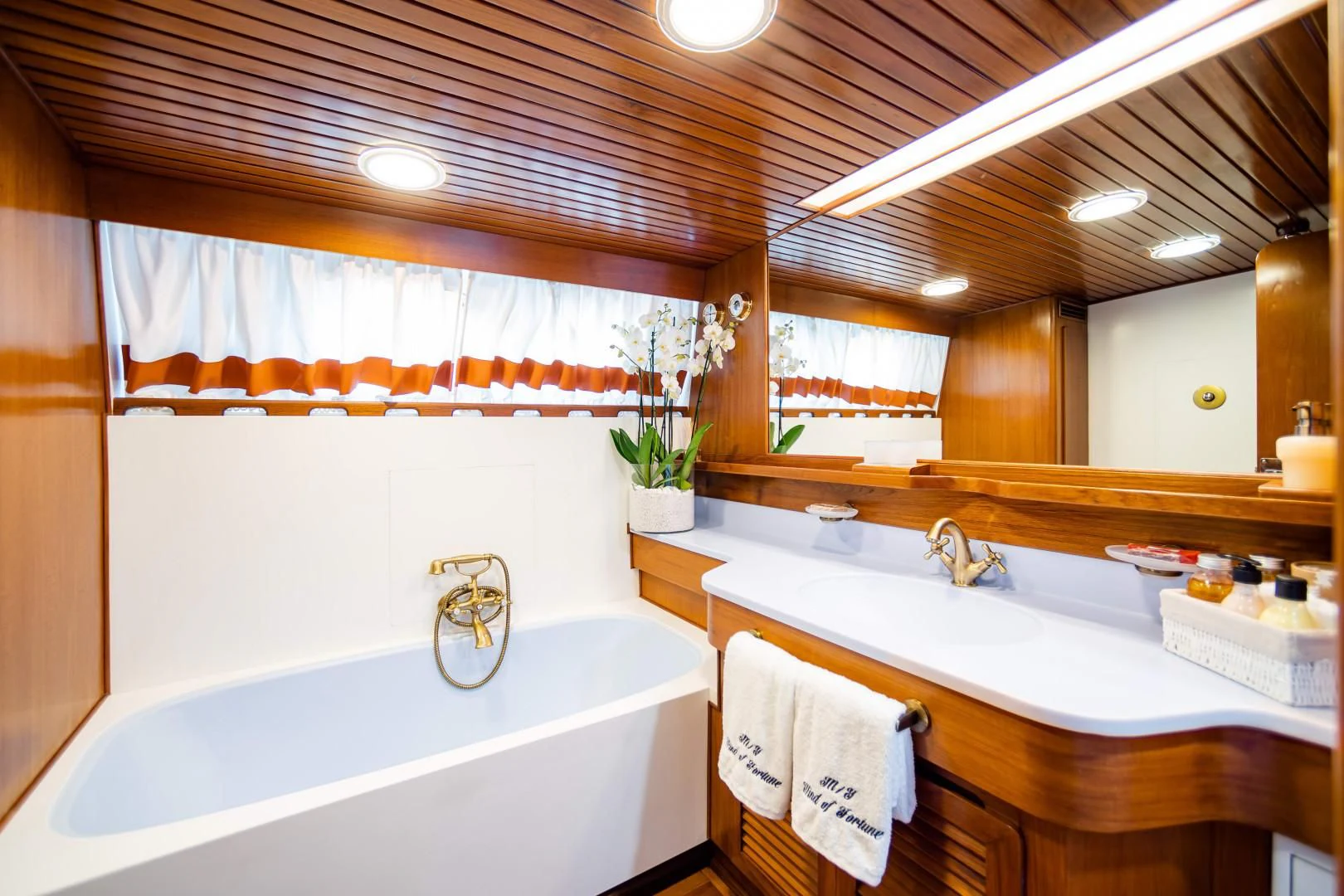 a bathroom with a tub sink and cabinets aboard WIND OF FORTUNE Yacht for Charter