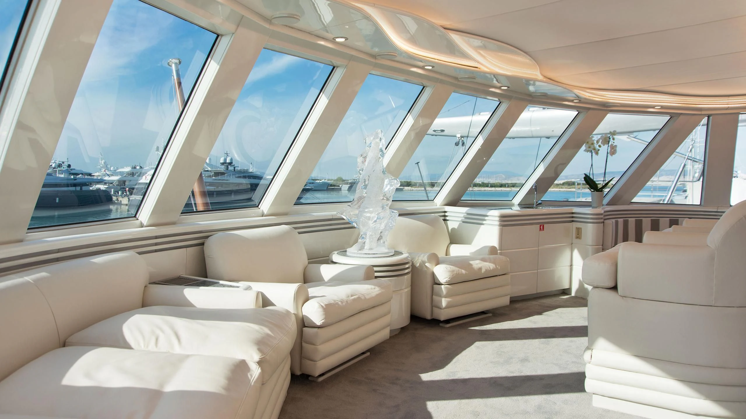 a room with a couch and a large window aboard WIND OF FORTUNE Yacht for Charter