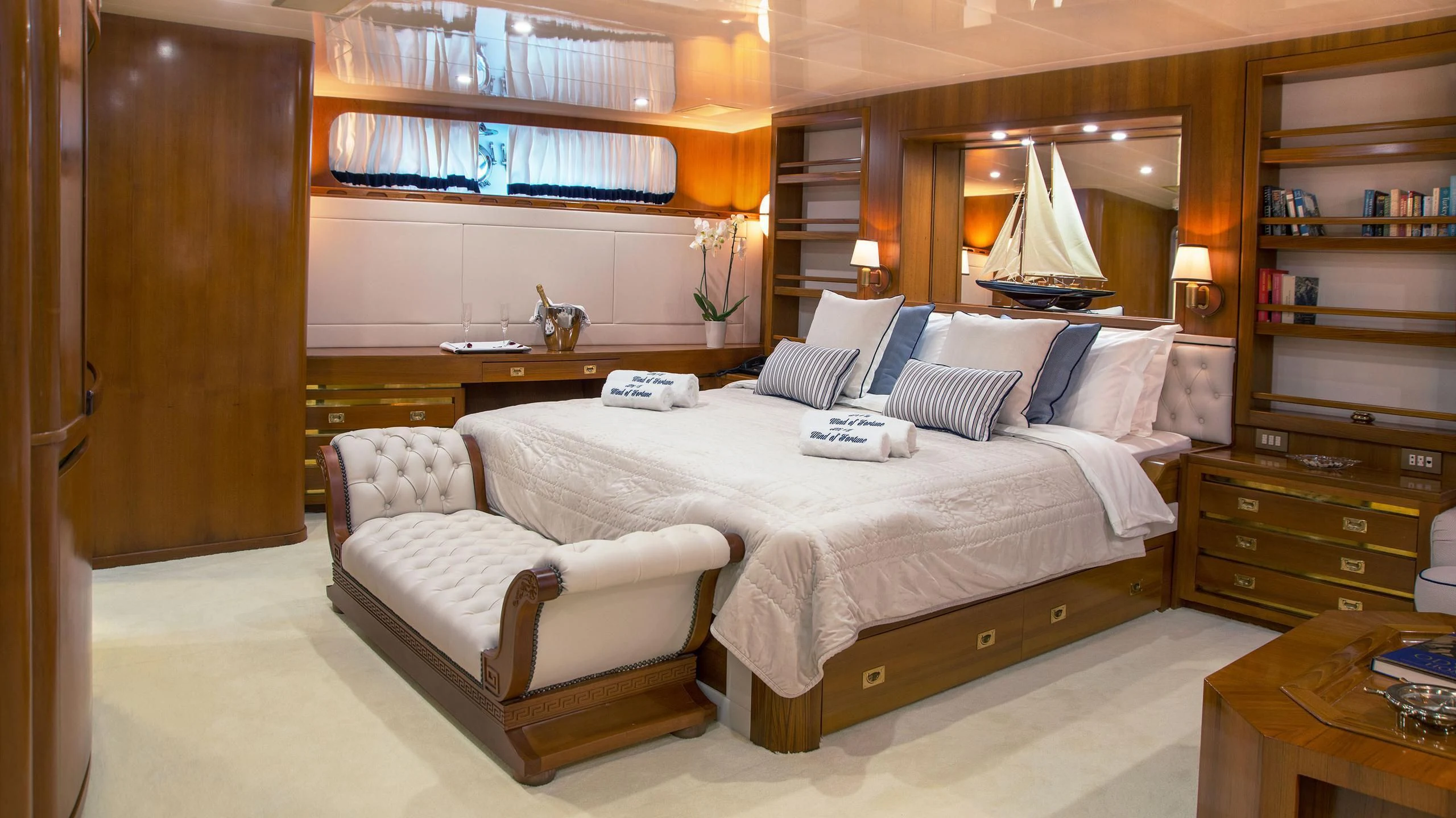 a bedroom with a bed and a desk aboard WIND OF FORTUNE Yacht for Charter