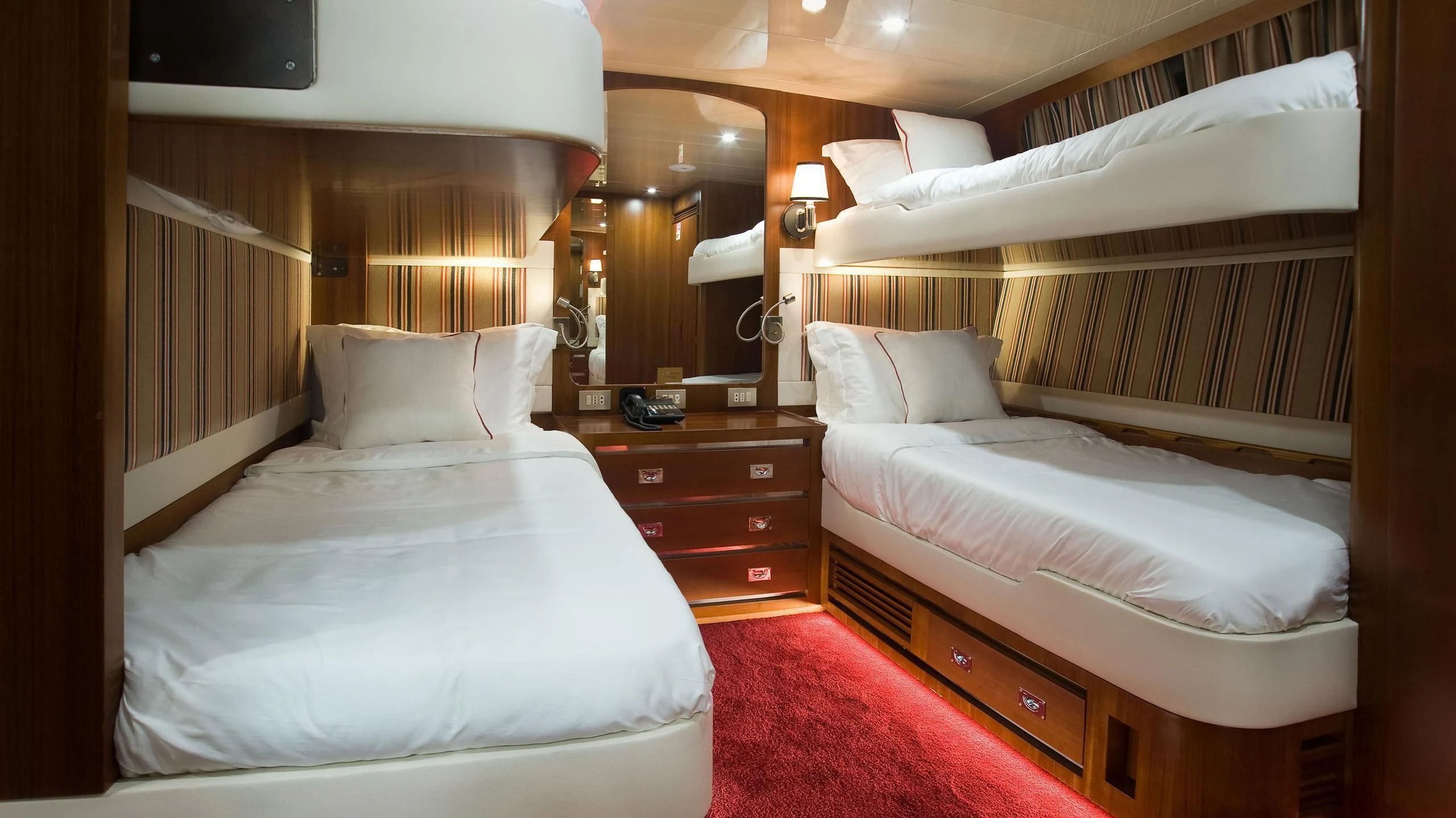 a room with beds and a dresser aboard WIND OF FORTUNE Yacht for Charter