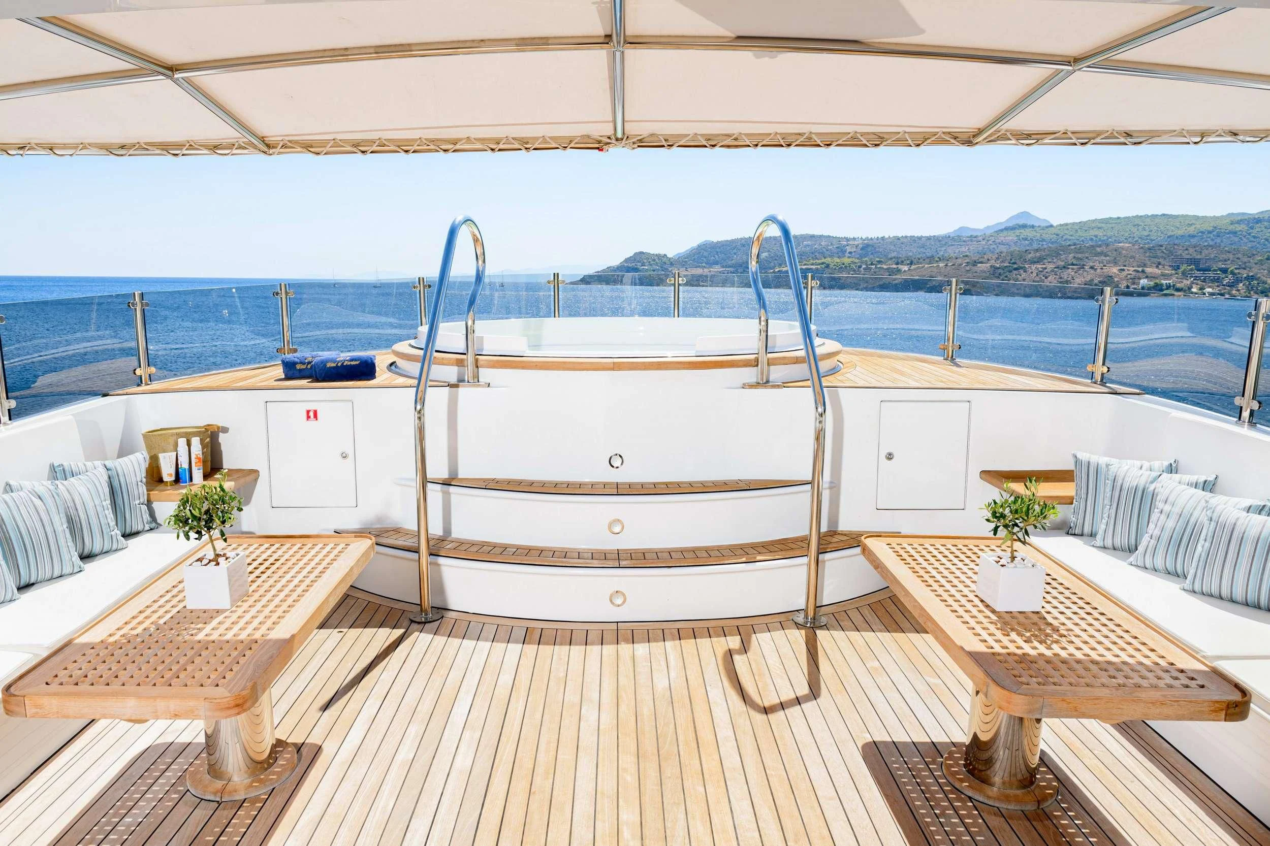 a deck with a table and chairs on it aboard WIND OF FORTUNE Yacht for Charter
