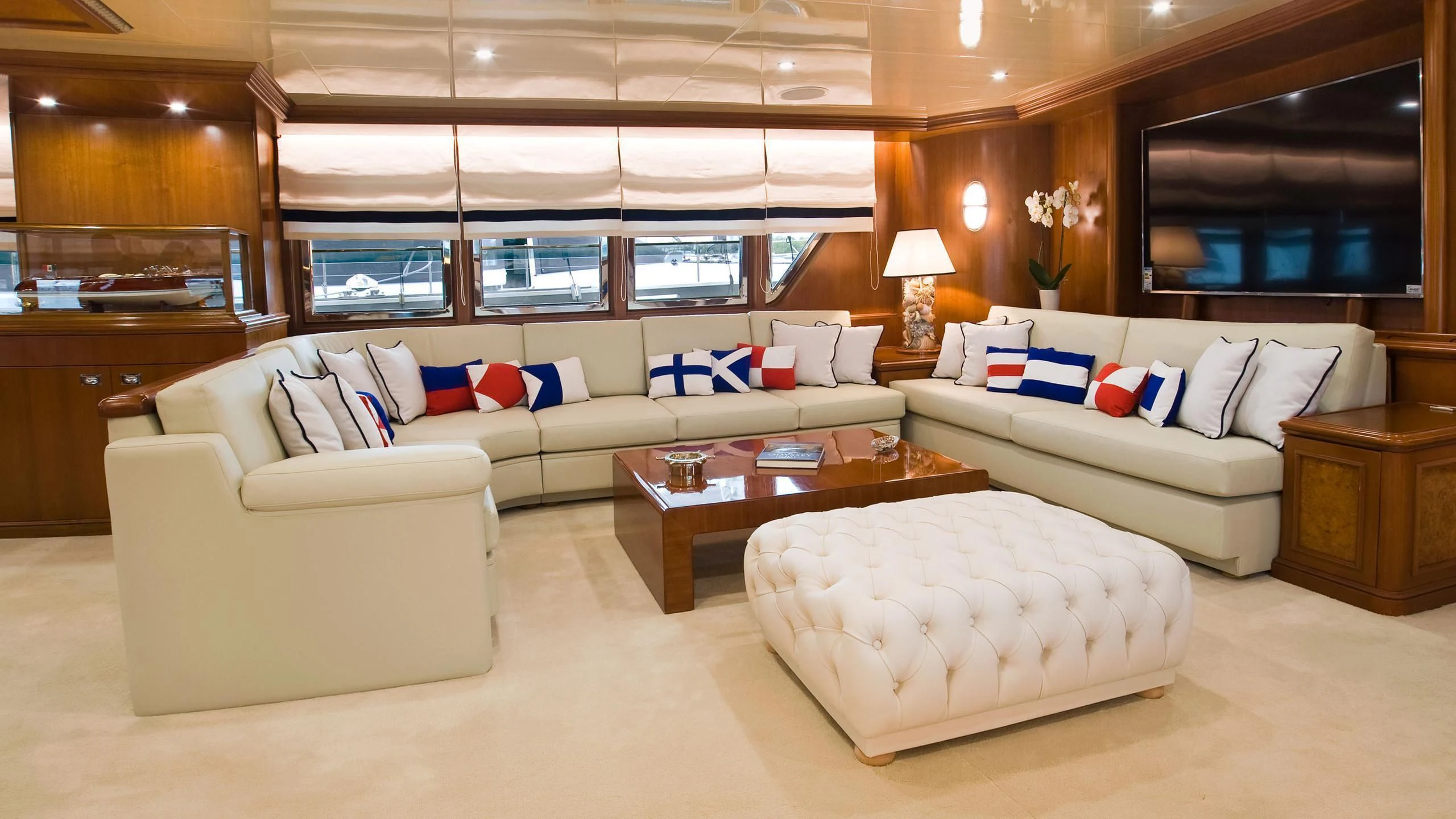 a large living room with a large white couch and a large window aboard WIND OF FORTUNE Yacht for Charter