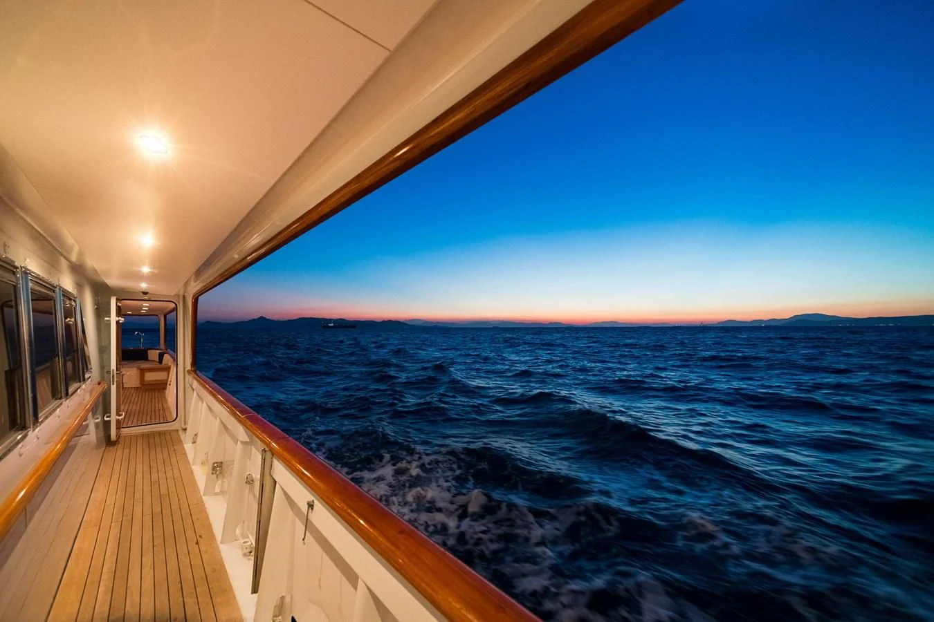 a long wooden dock leading to a beach with a large body of water aboard WIND OF FORTUNE Yacht for Charter