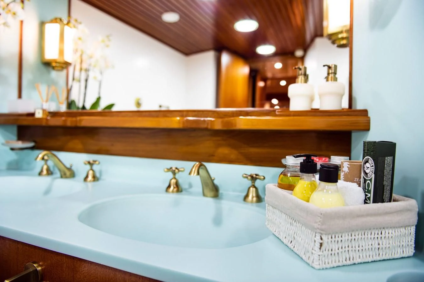 a bathroom with a sink and many bottles of soap aboard WIND OF FORTUNE Yacht for Charter