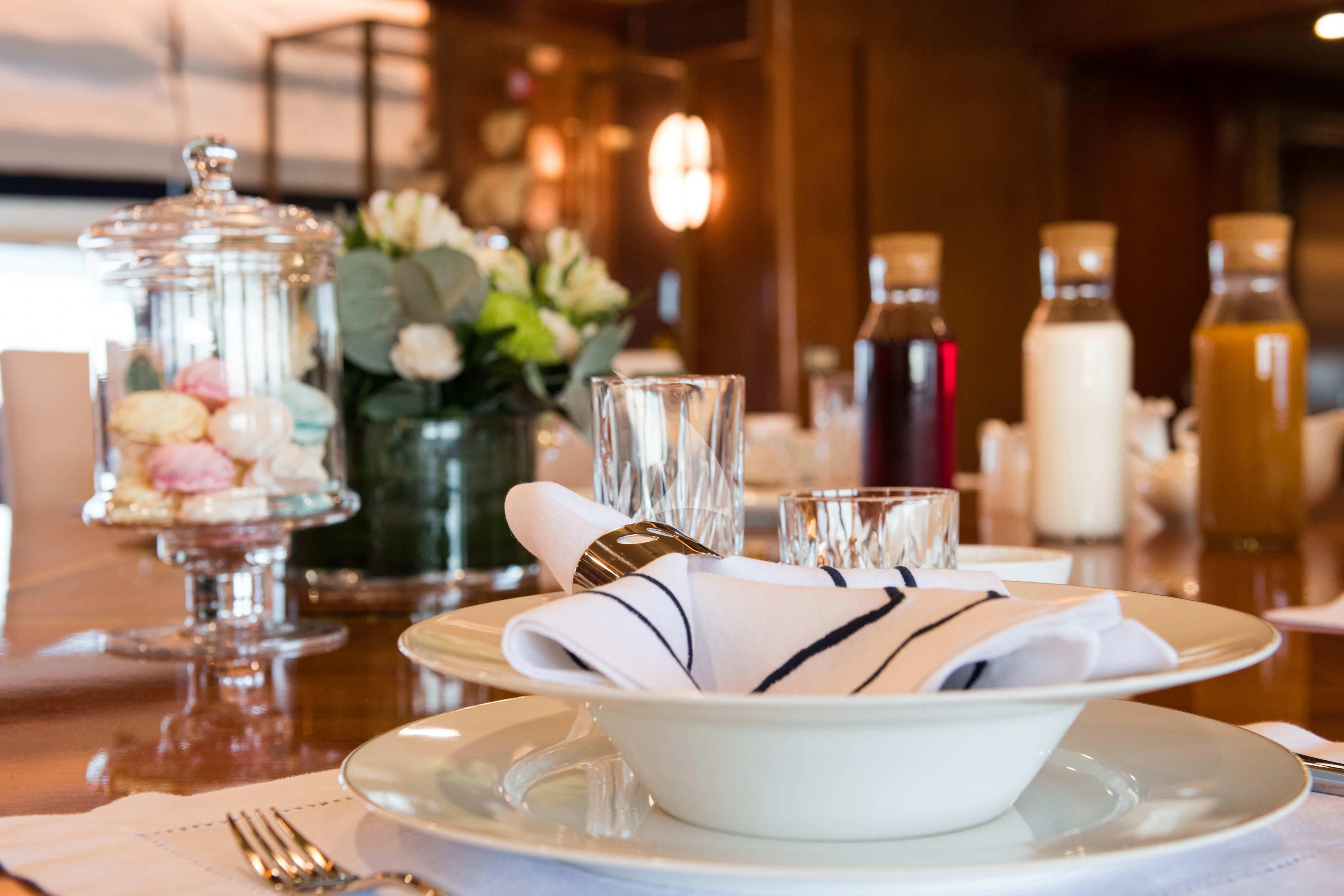 a table with a plate of desserts and glasses aboard WIND OF FORTUNE Yacht for Charter