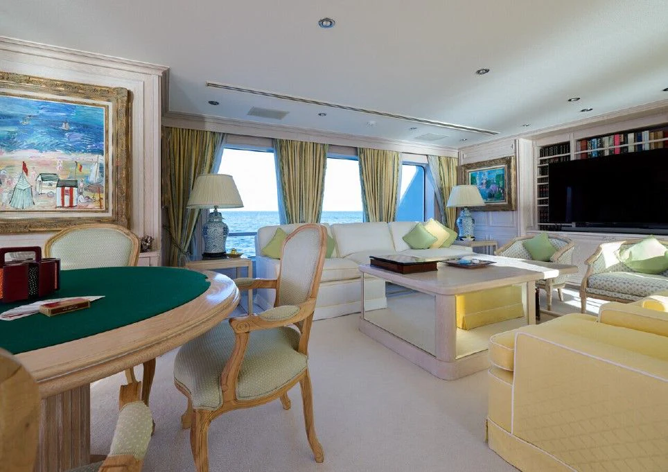 a living room with a tv and a table aboard LADY BEATRICE Yacht for Sale