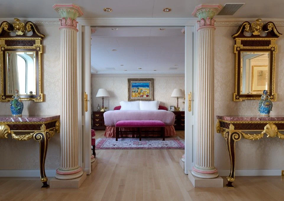 a large living room with a pink couch and a mirror aboard LADY BEATRICE Yacht for Sale
