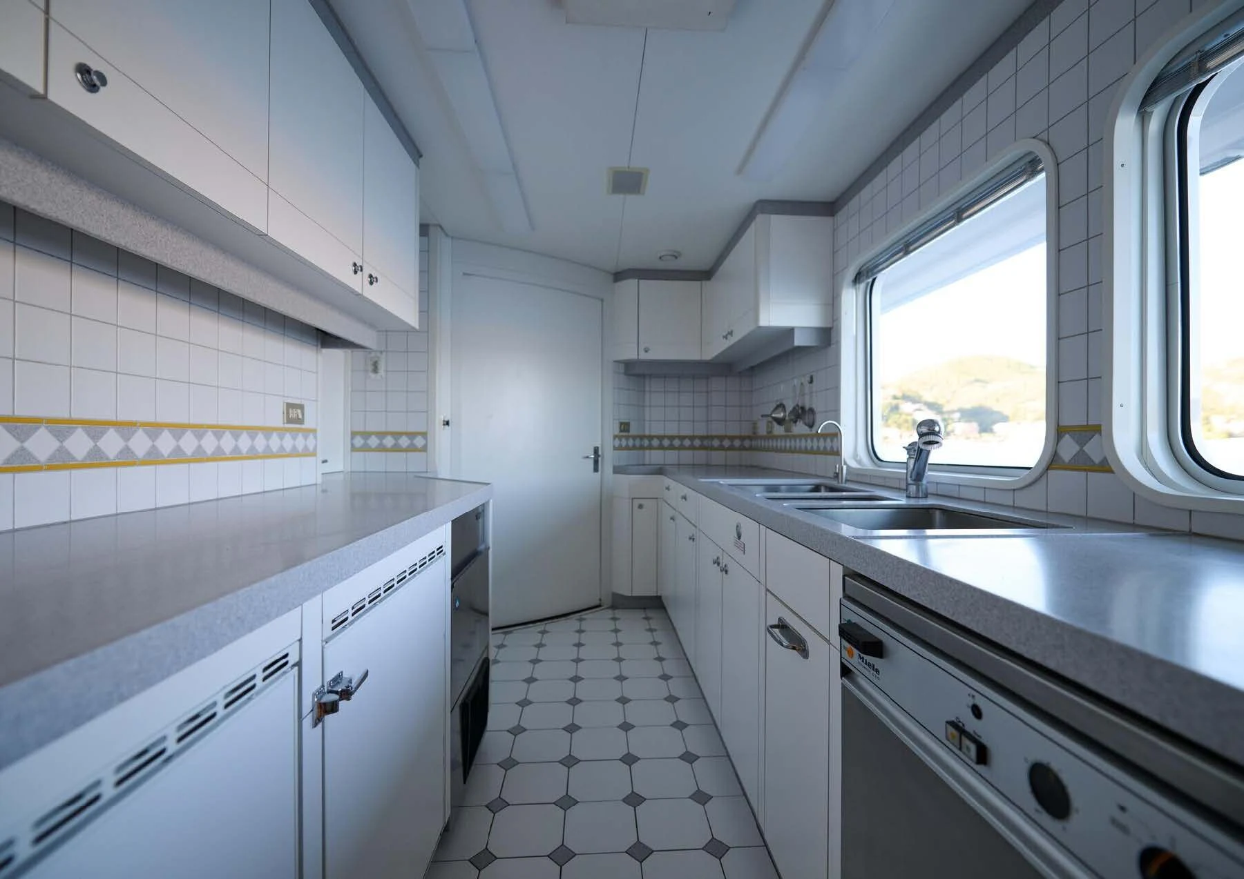 a kitchen with white cabinets aboard LADY BEATRICE Yacht for Sale