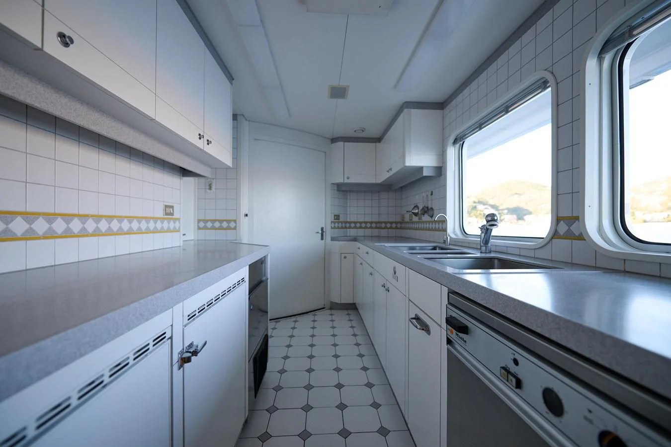 a kitchen with white cabinets aboard LADY BEATRICE Yacht for Sale