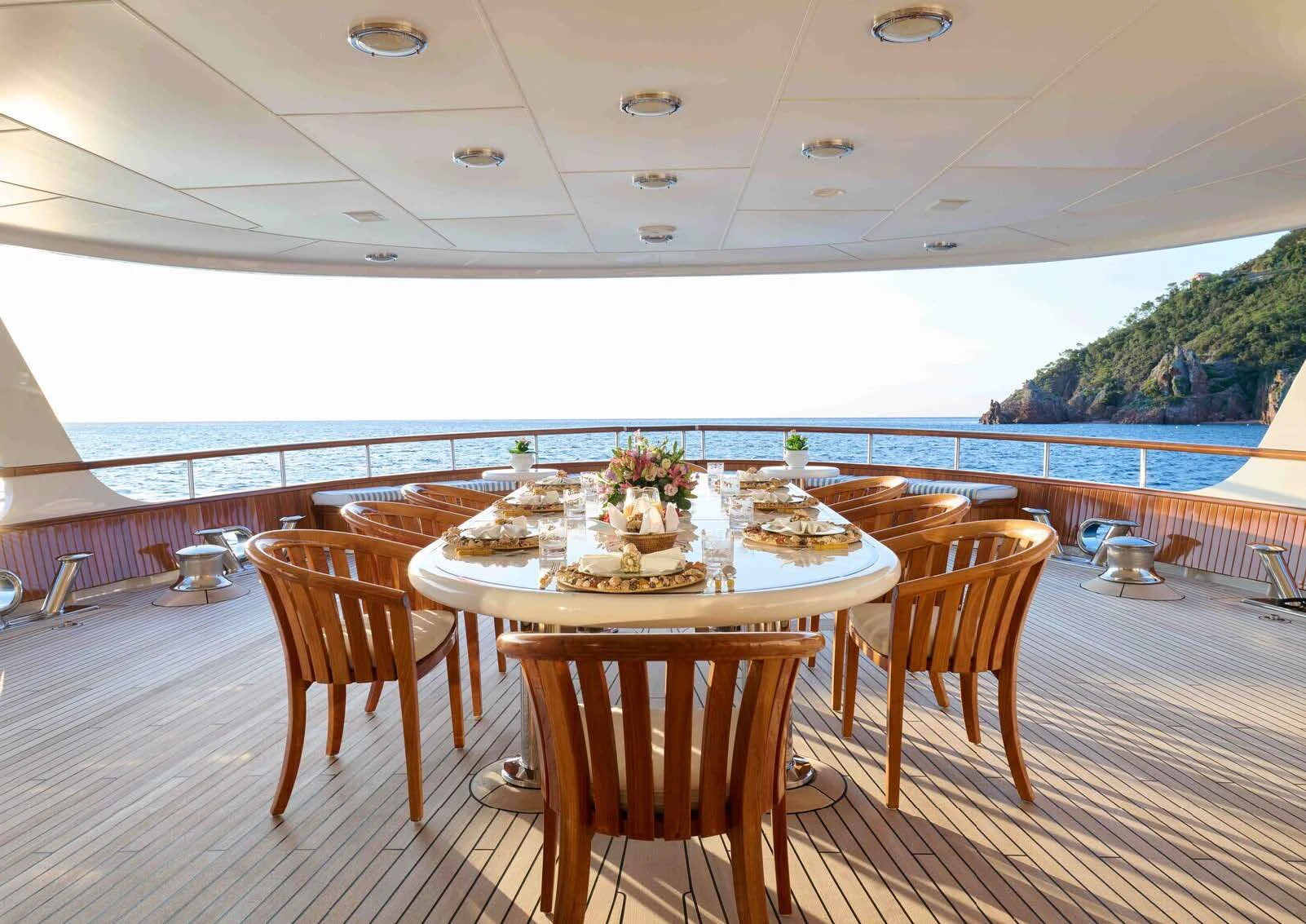 a table set for a meal on a deck overlooking a large body of water aboard LADY BEATRICE Yacht for Sale
