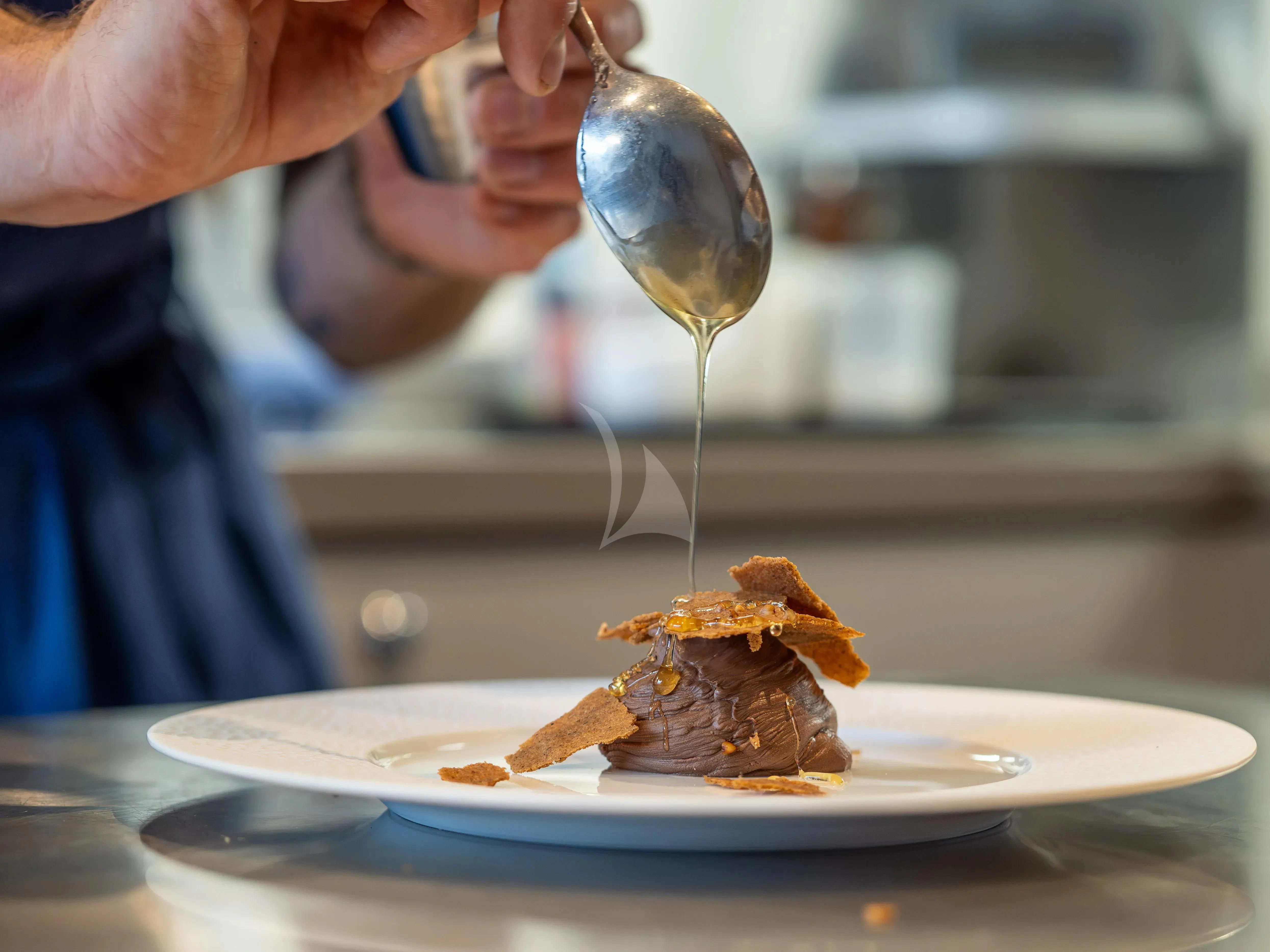 a person pouring chocolate into a glass aboard HANA Yacht for Charter