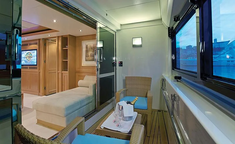a room with a bed and a table and chairs aboard HANA Yacht for Charter