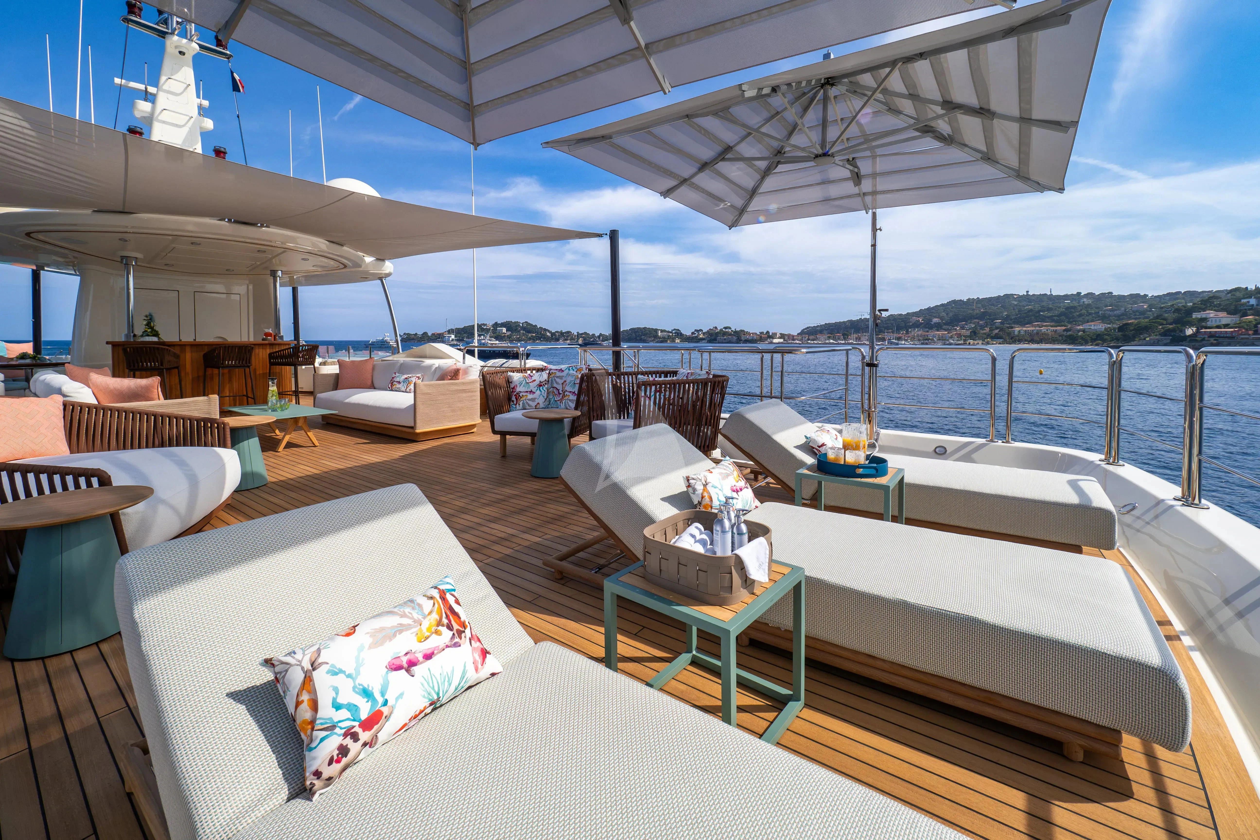 a deck with a view of the ocean and the ocean aboard HANA Yacht for Charter