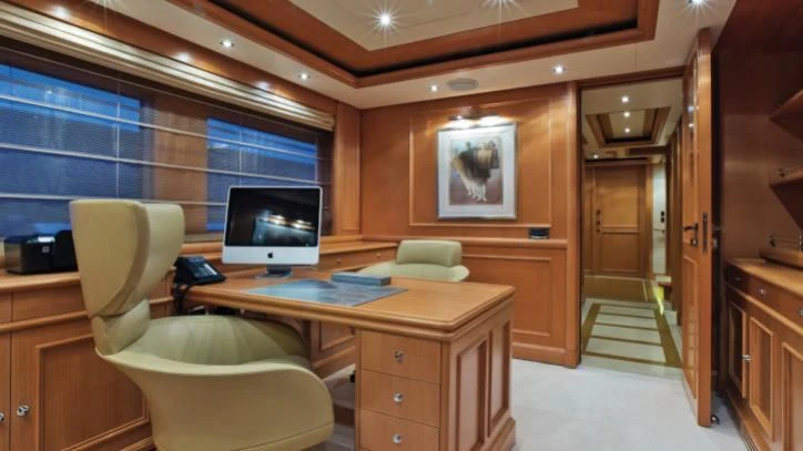 a room with a desk and a tv aboard HANA Yacht for Charter