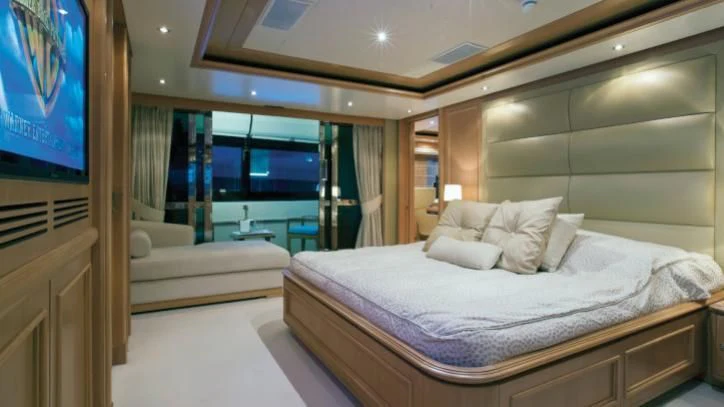 a room with a bed and a television aboard HANA Yacht for Charter