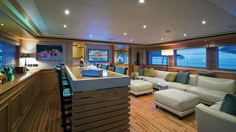 a large living room with a bar and a large window aboard HANA Yacht for Charter