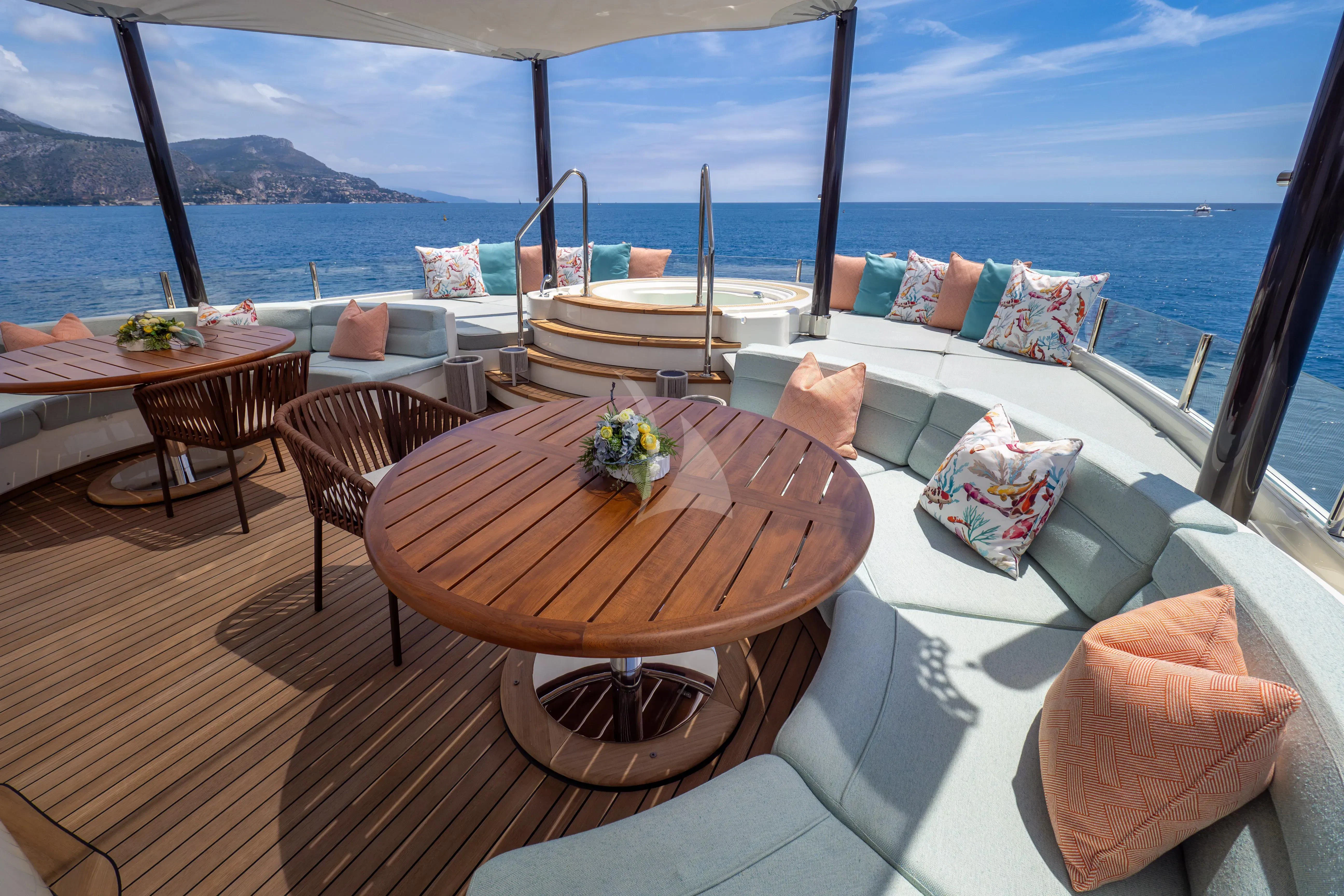 a table with chairs and a view of the ocean aboard HANA Yacht for Charter