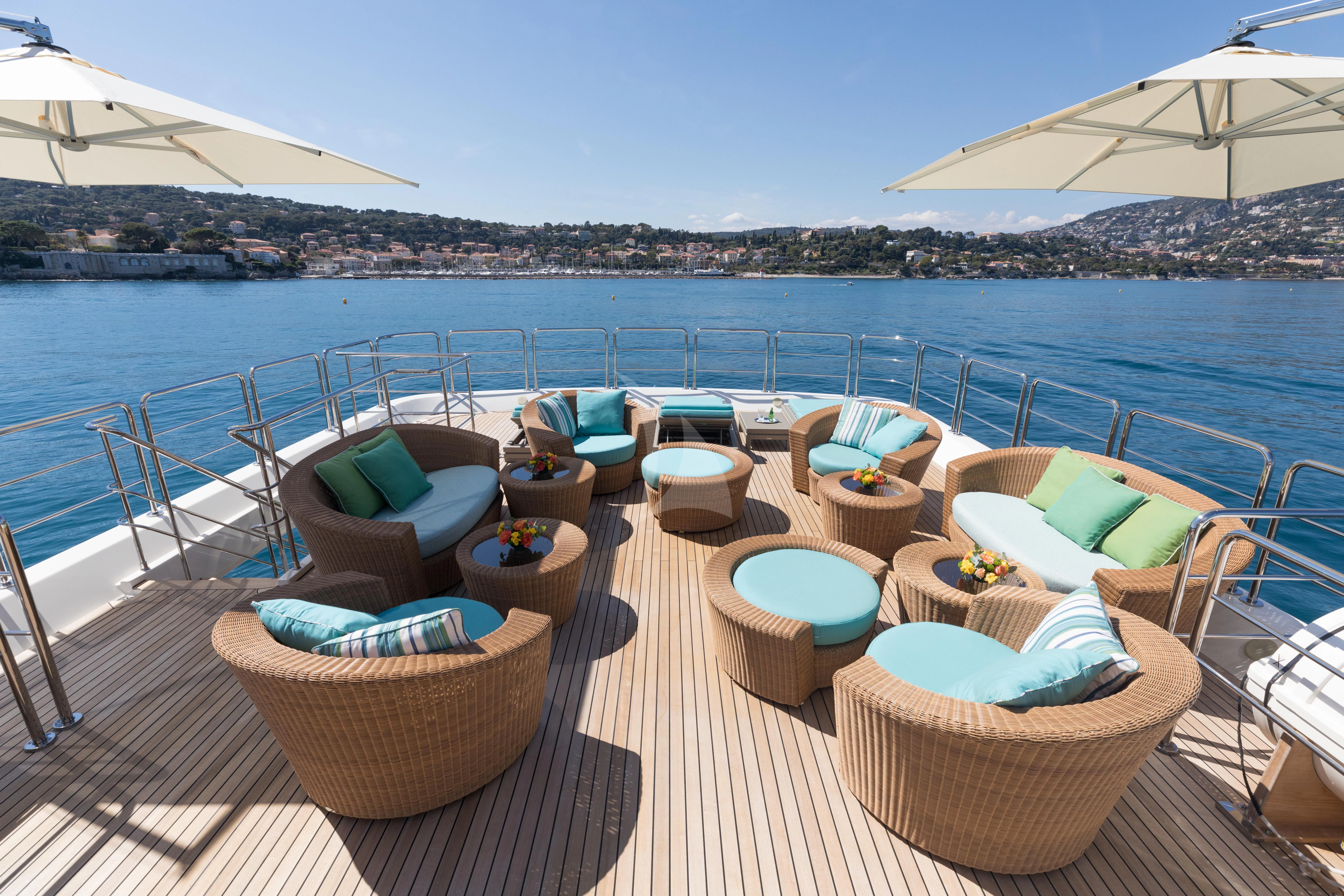 a deck with lounge chairs and umbrellas on it aboard HANA Yacht for Charter