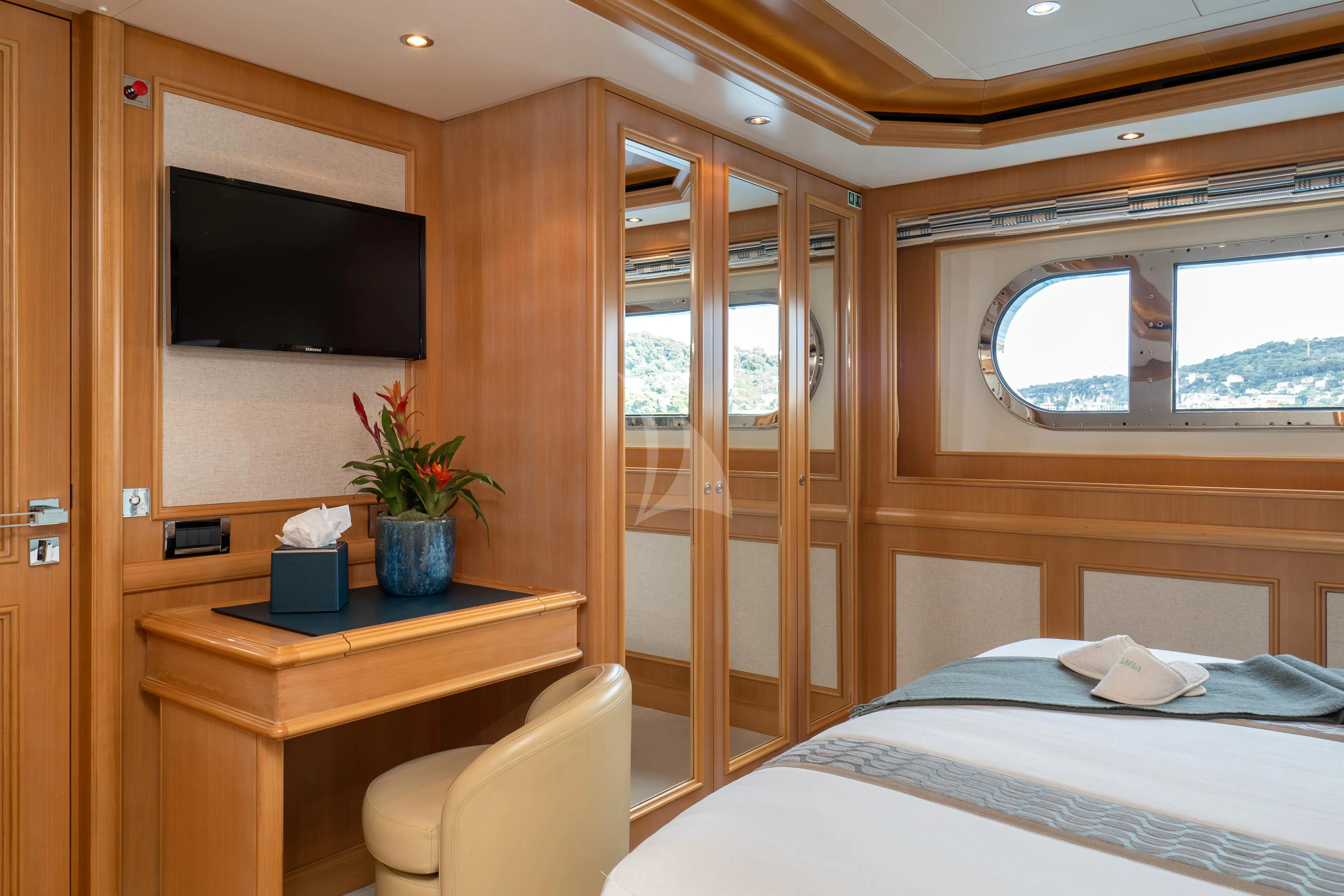 a room with a bed and a television aboard HANA Yacht for Charter