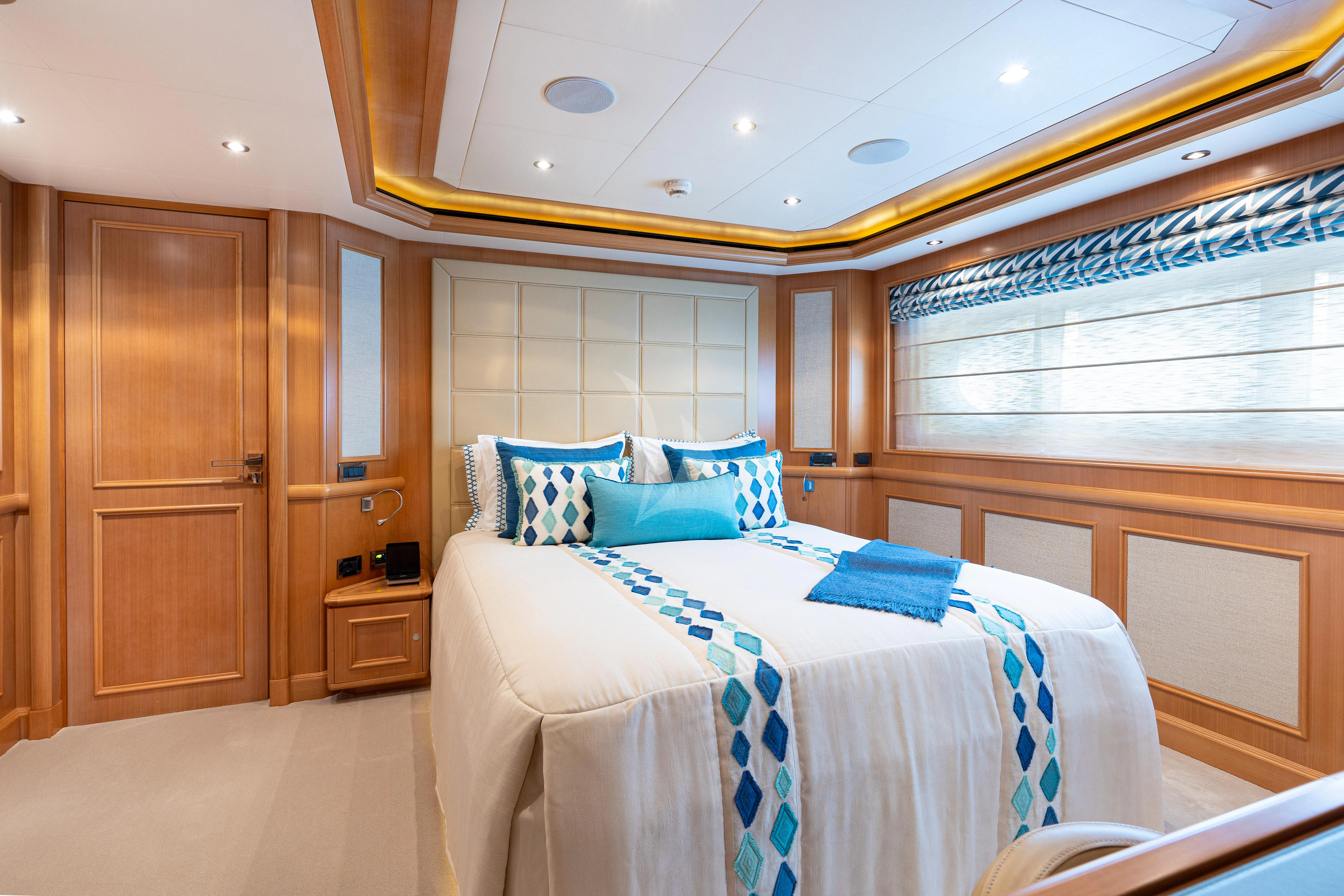 a bedroom with a bed and a wood door aboard HANA Yacht for Charter
