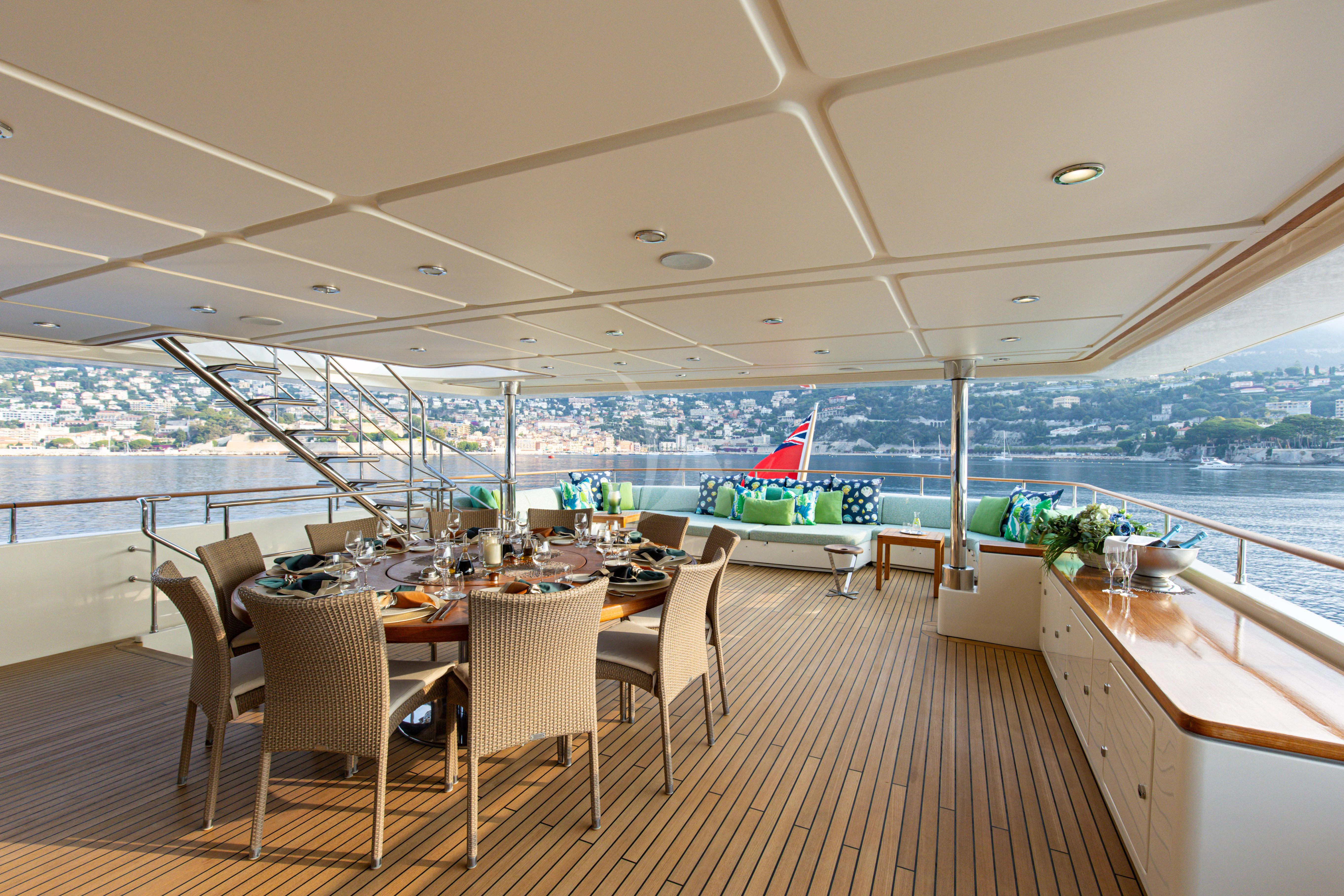 a room with tables and chairs aboard HANA Yacht for Charter