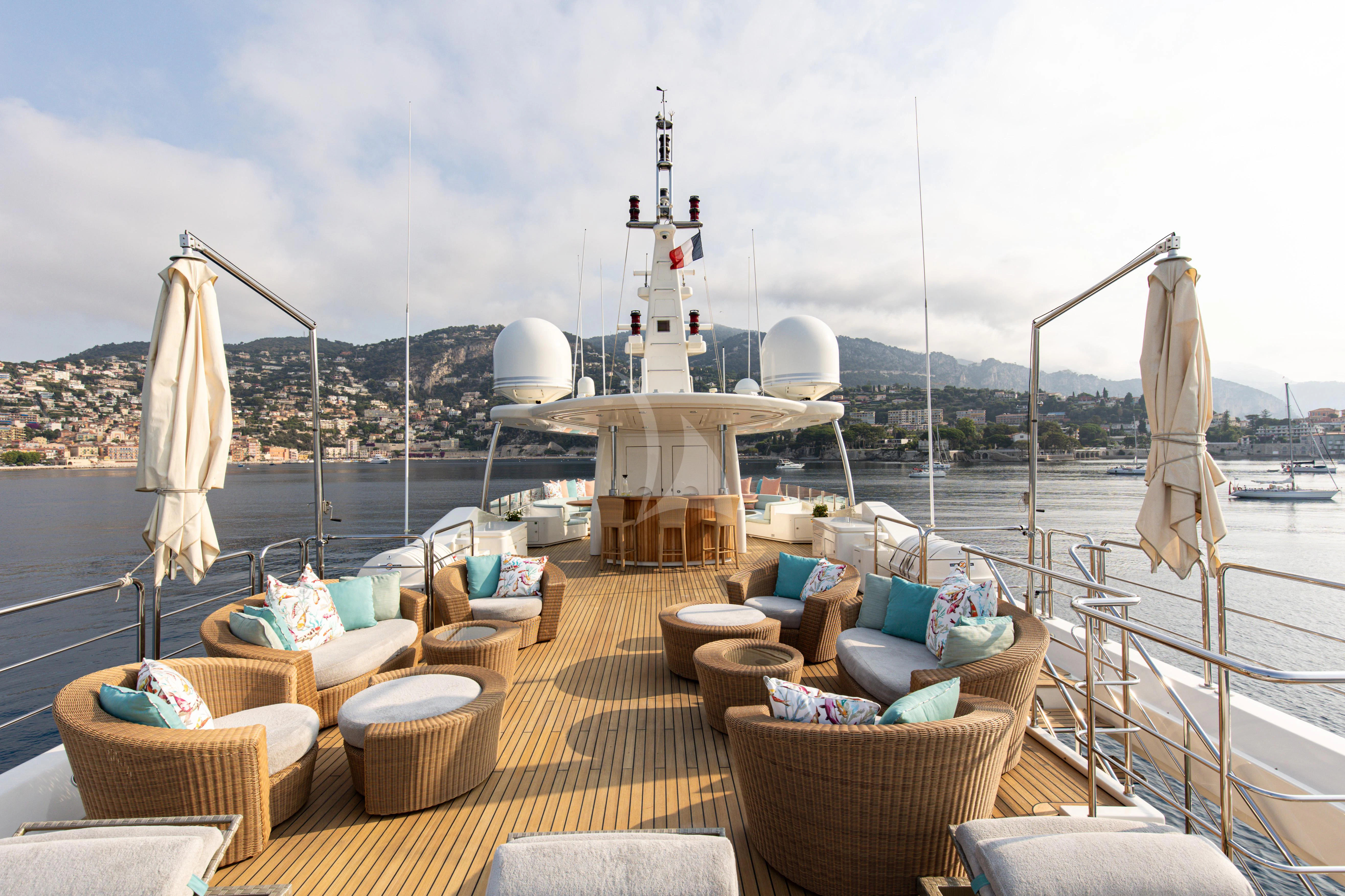 a deck with a boat and chairs on it aboard HANA Yacht for Charter