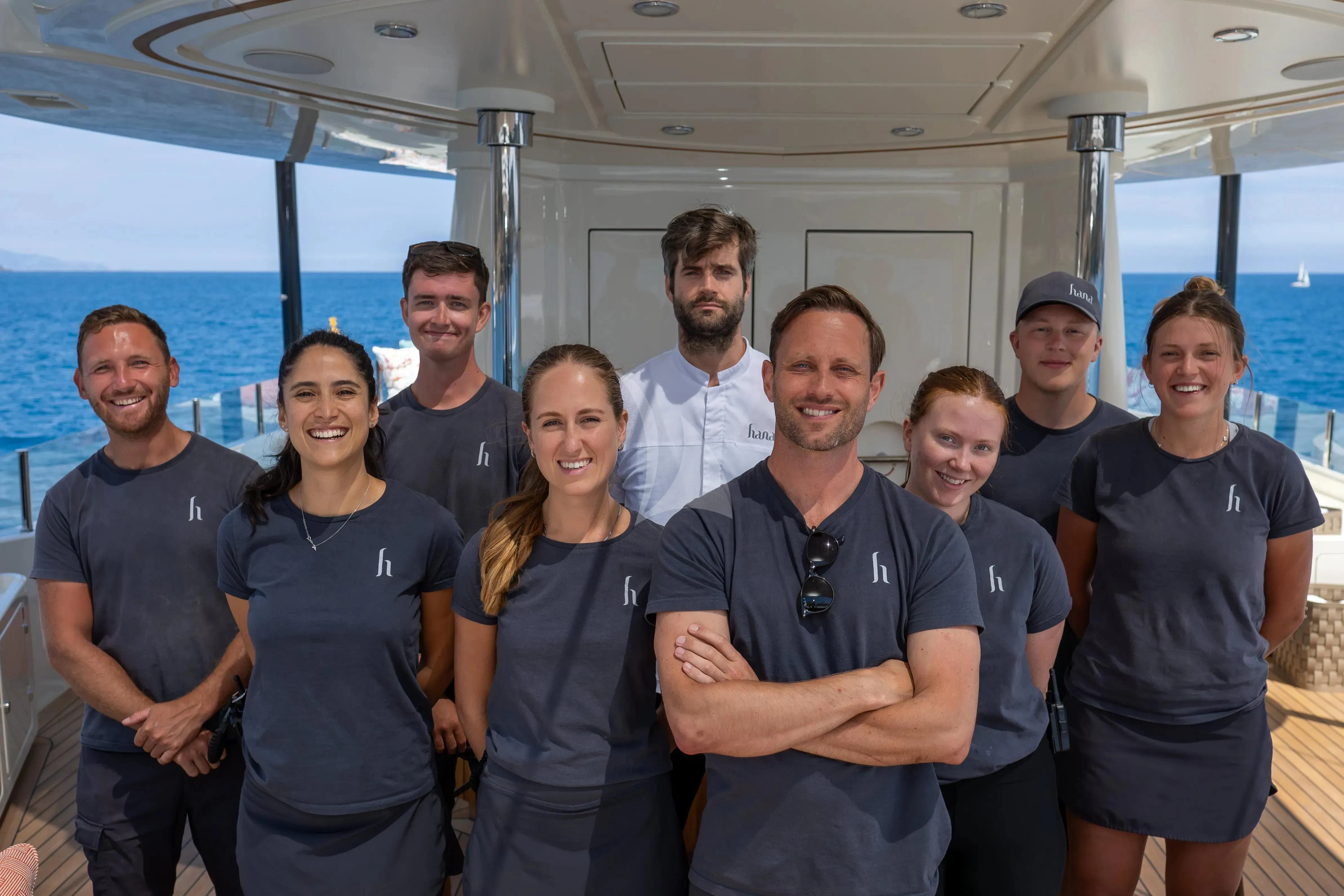 a group of people posing for a photo aboard HANA Yacht for Charter