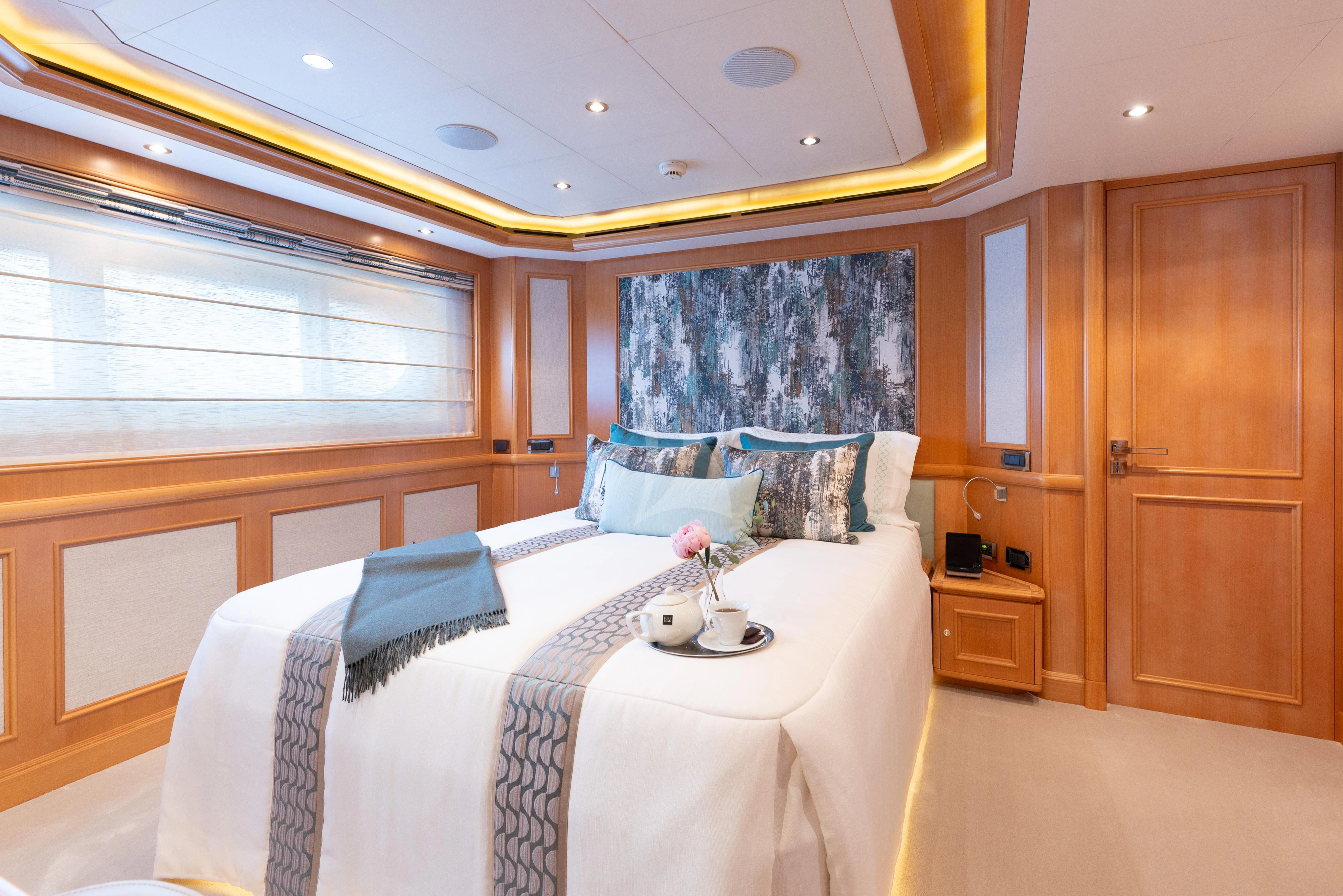 a bedroom with a bed and a window aboard HANA Yacht for Charter