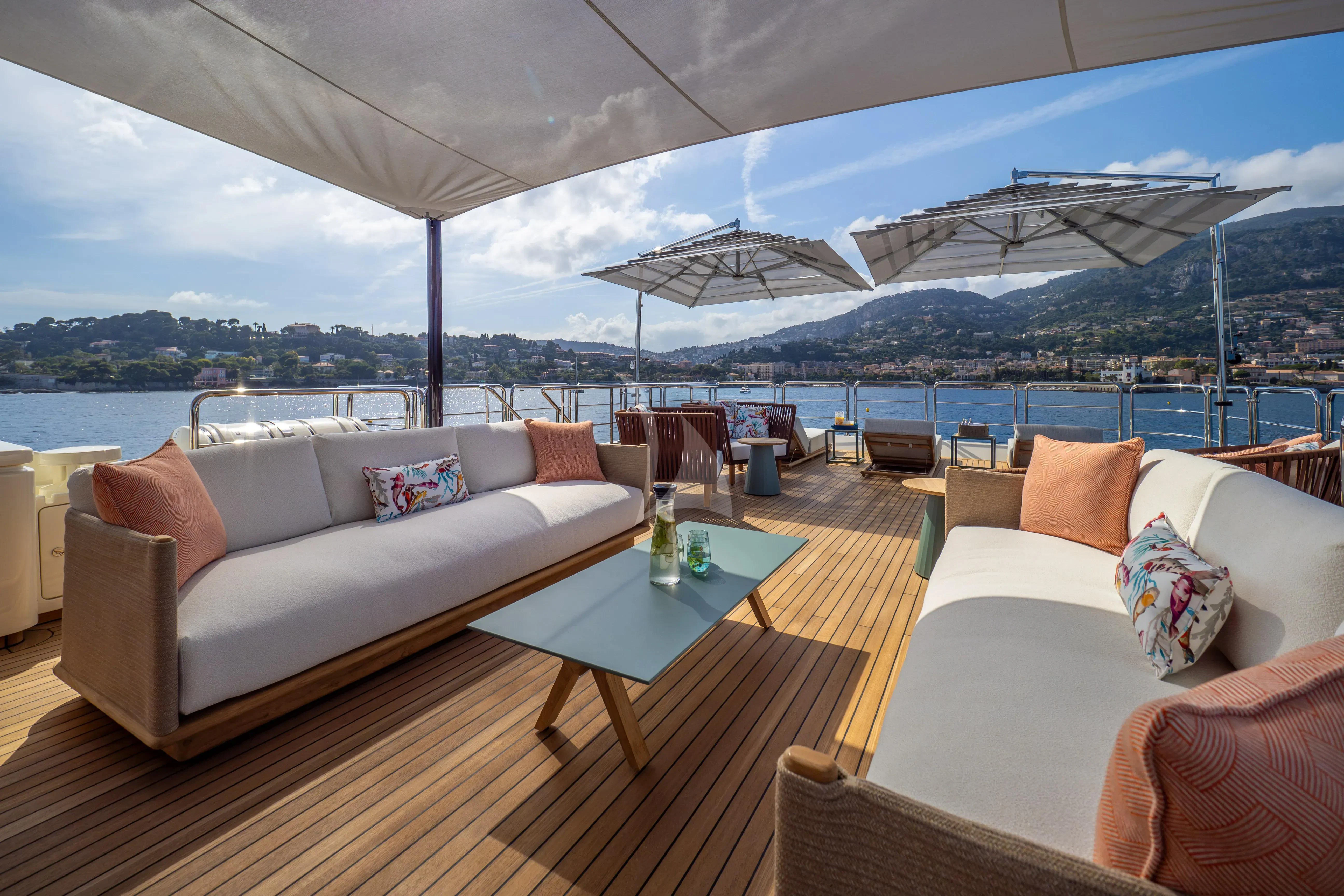 a large white tent with a table and chairs in front of it aboard HANA Yacht for Charter
