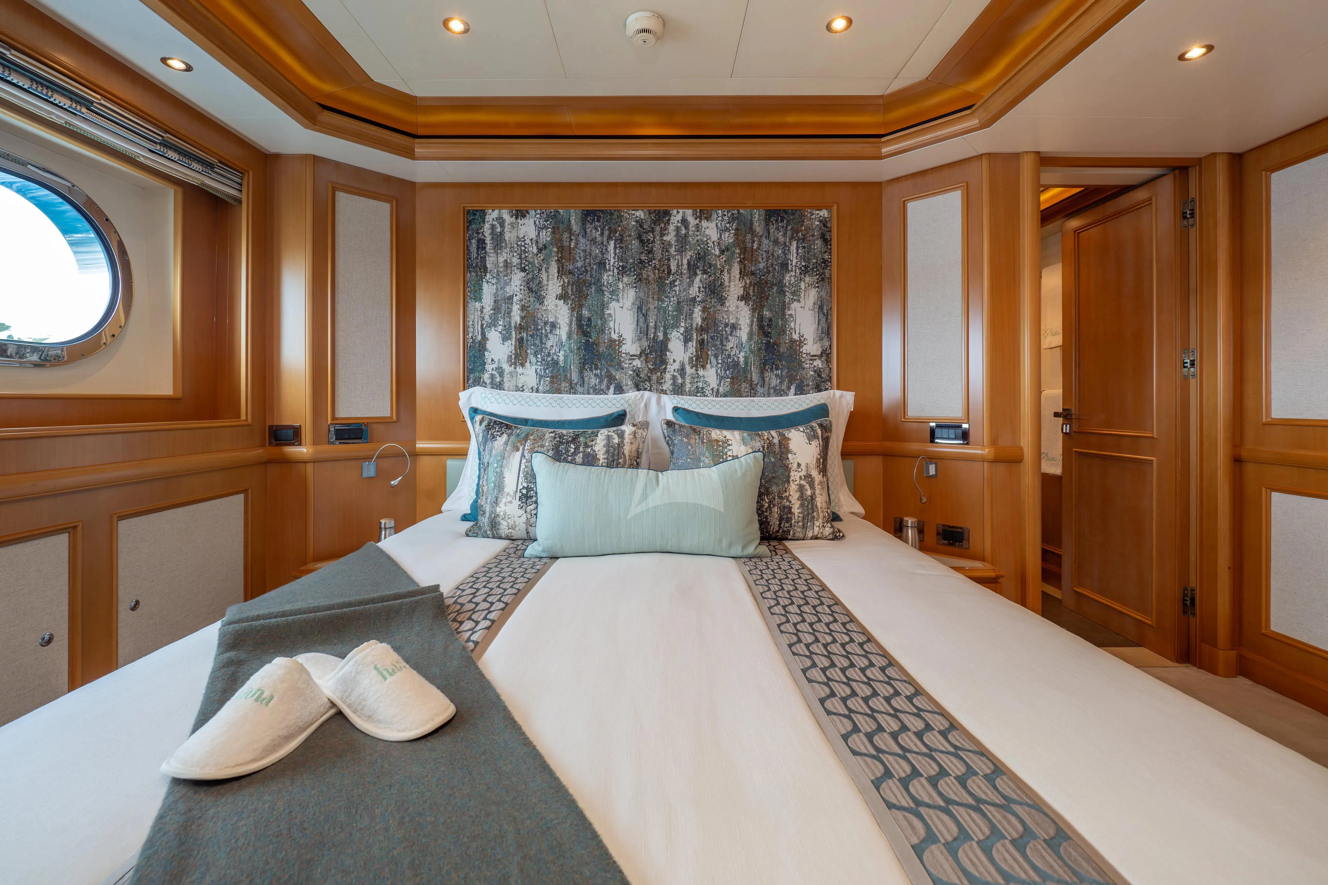 a bed with white sheets aboard HANA Yacht for Charter