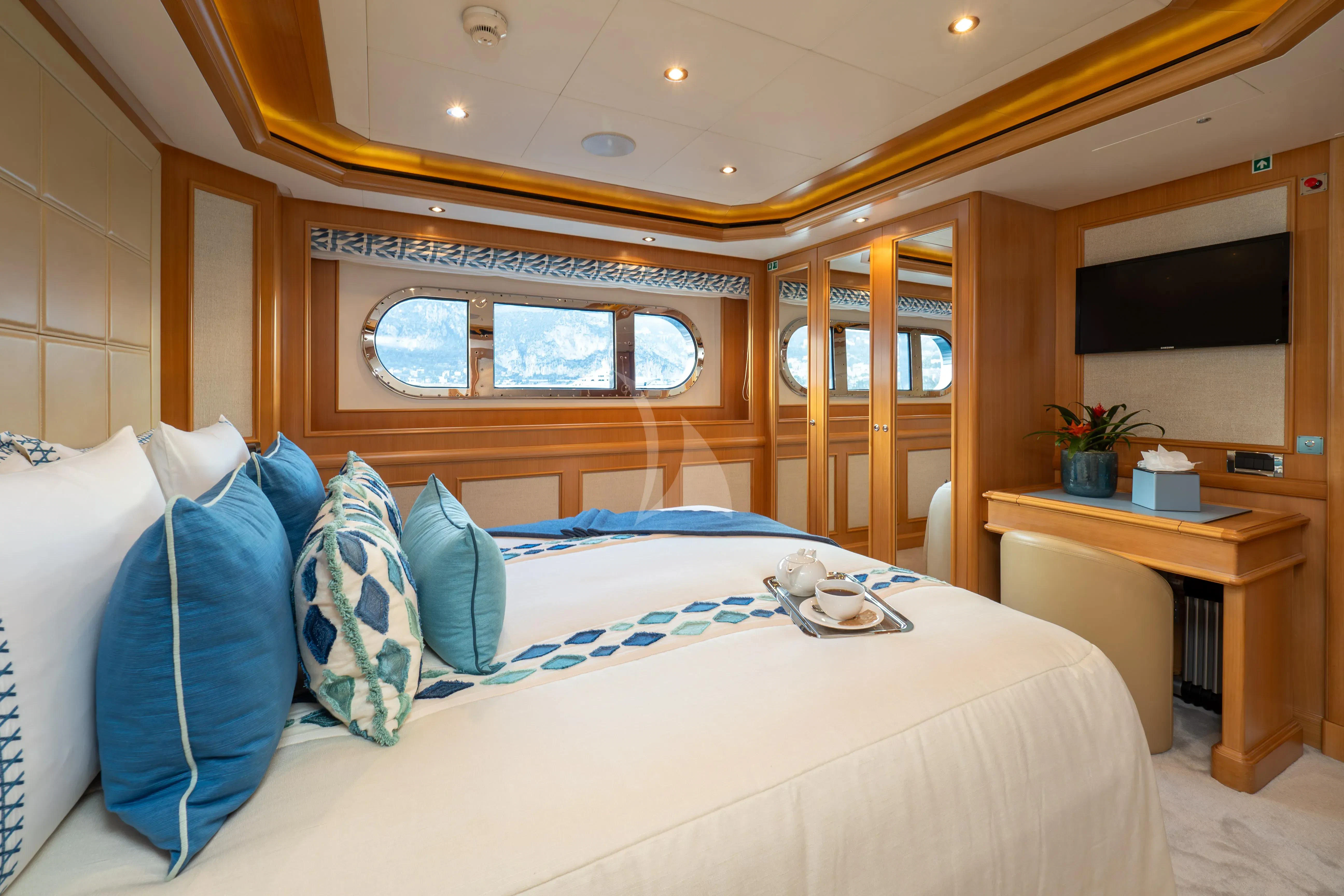 a bed with blue pillows aboard HANA Yacht for Charter