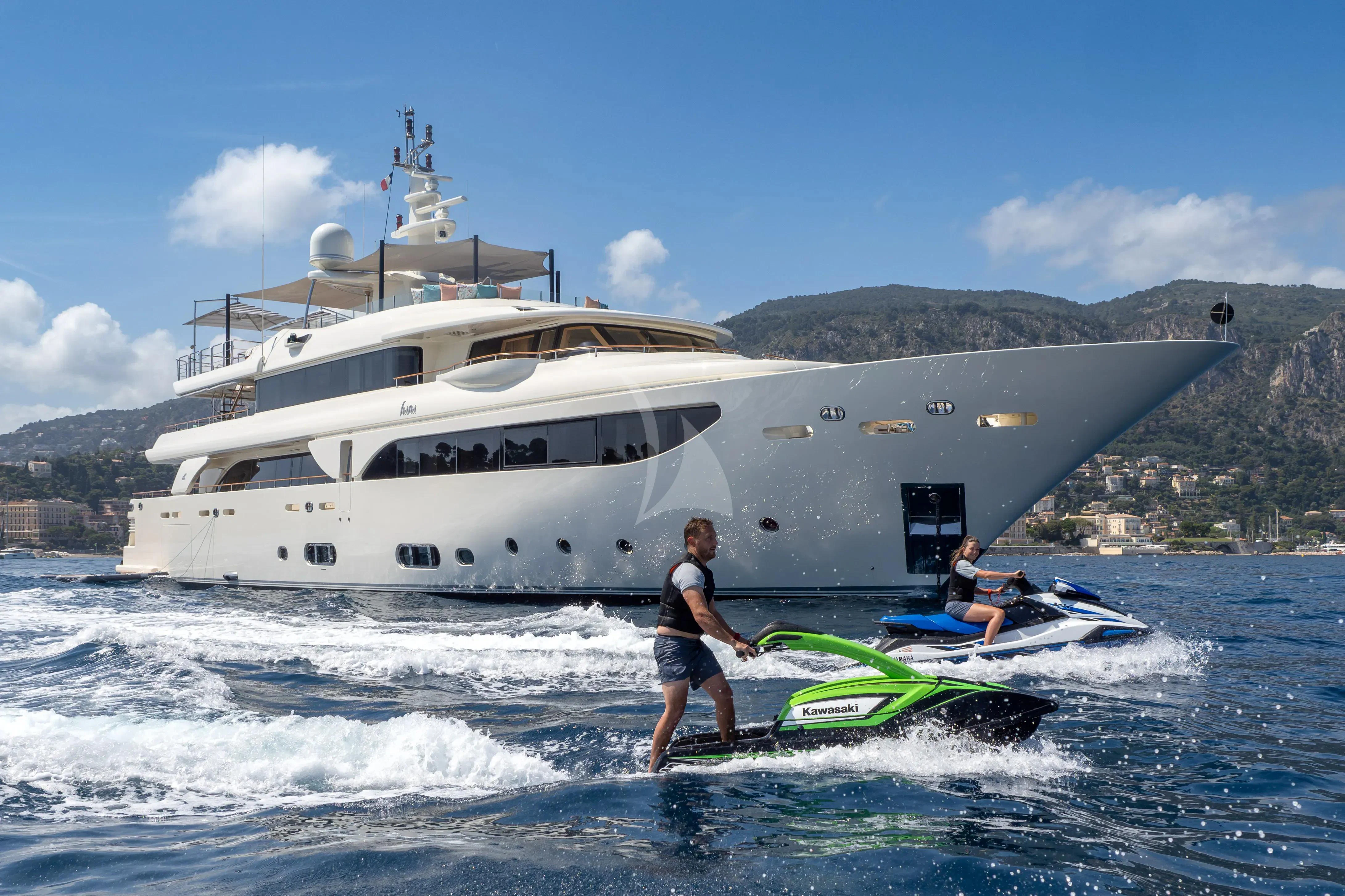 a man and a woman on a surfboard in the ocean aboard HANA Yacht for Charter