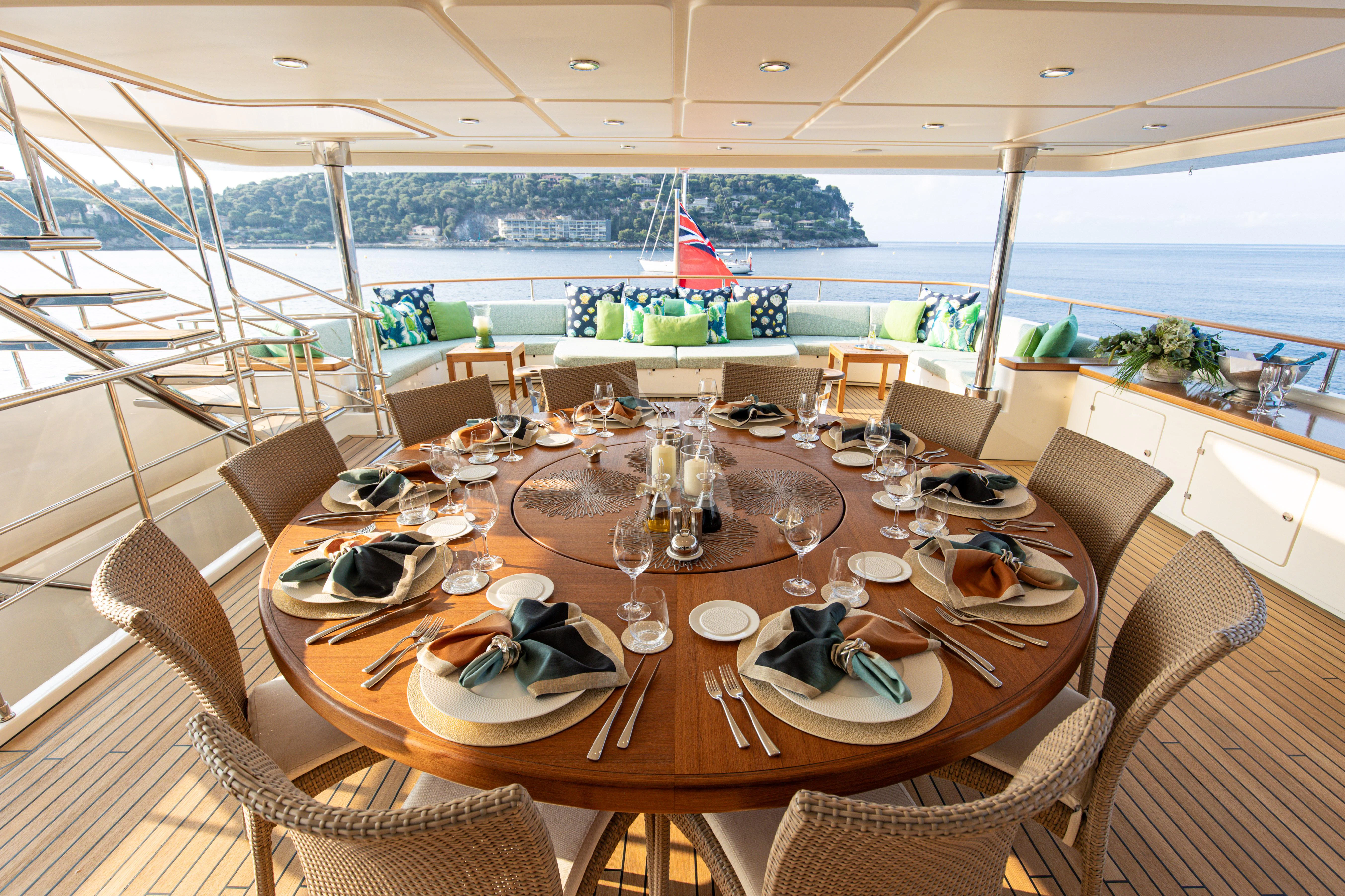 a table set for a meal on a deck aboard HANA Yacht for Charter