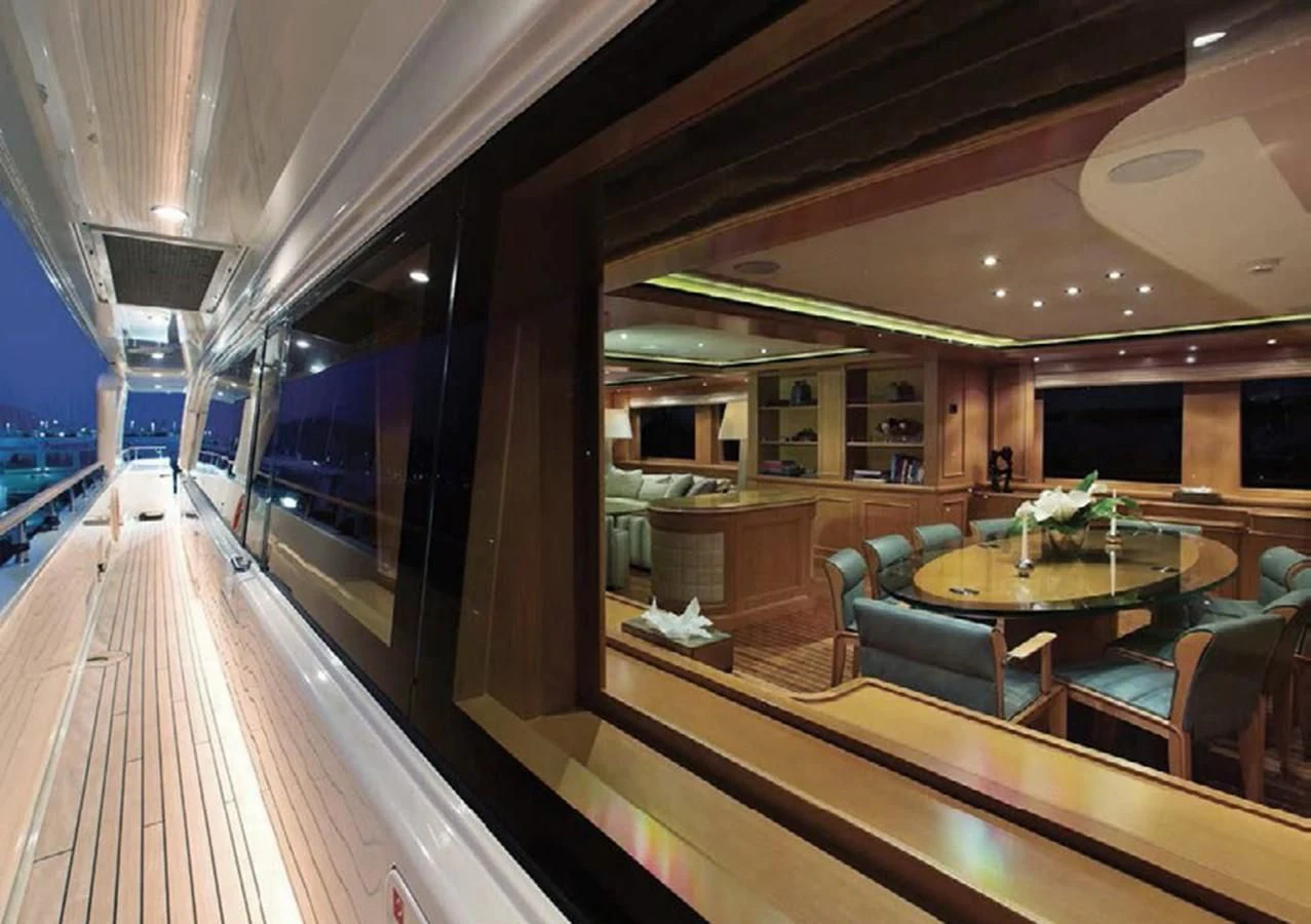 a room with tables and chairs aboard HANA Yacht for Charter