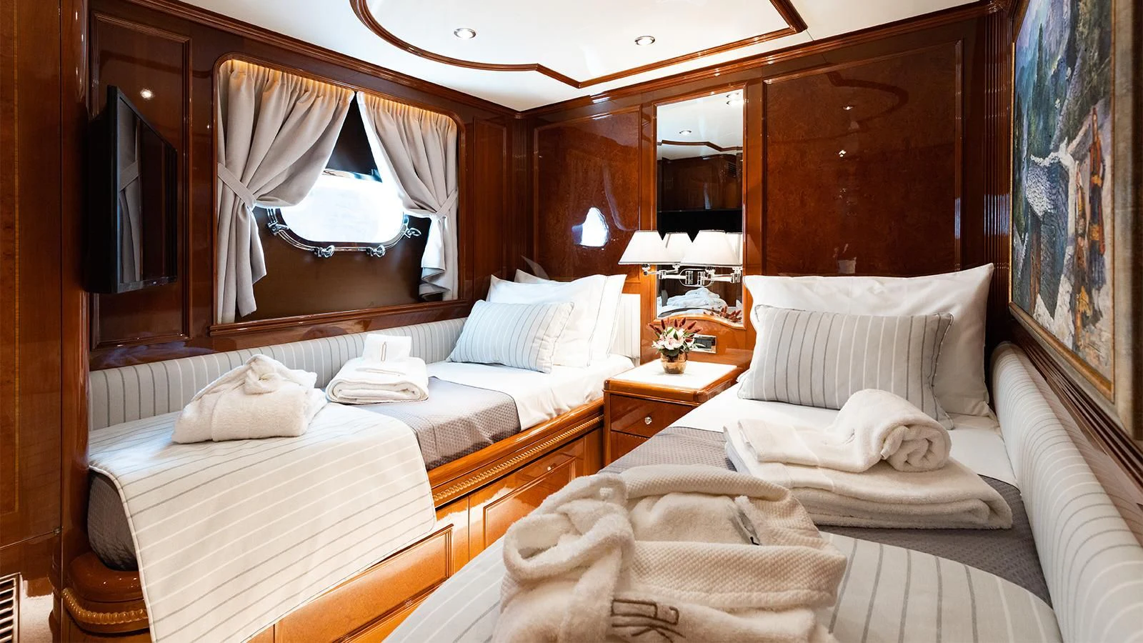 a room with beds and a large mirror aboard OAK Yacht for Charter
