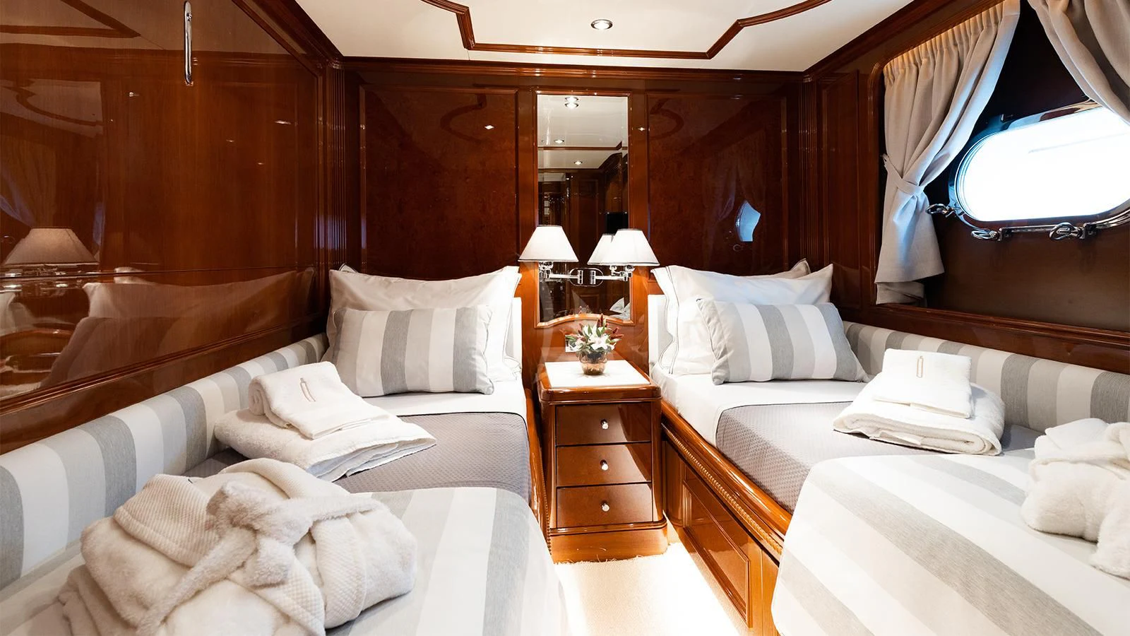 a room with beds and a dresser aboard OAK Yacht for Charter