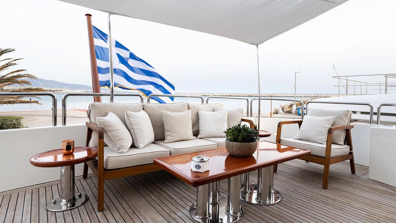a large white couch and table with a table and chairs on a deck aboard OAK Yacht for Charter