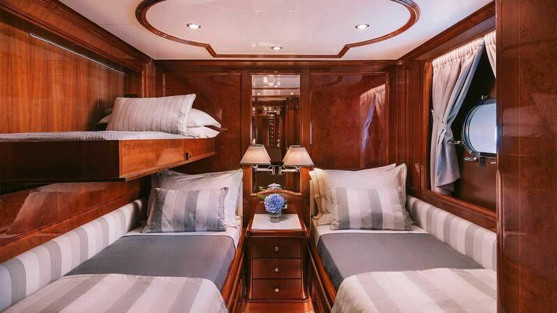 a room with beds and a mirror aboard OAK Yacht for Charter