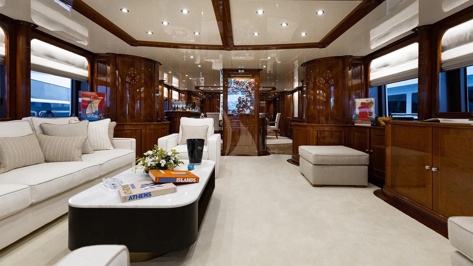 a large living room with a large wood cabinet and white couches aboard OAK Yacht for Charter