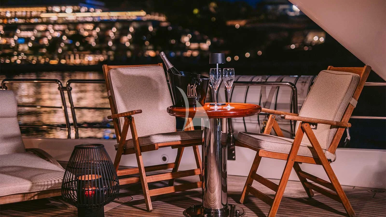 a table set with chairs and a view of a city aboard OAK Yacht for Charter