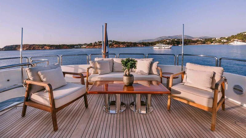 a table and chairs on a deck overlooking a body of water aboard OAK Yacht for Charter