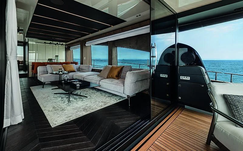 a living room with a large balcony aboard CRANCHI SETTANTOTTO 78/01 Yacht for Sale