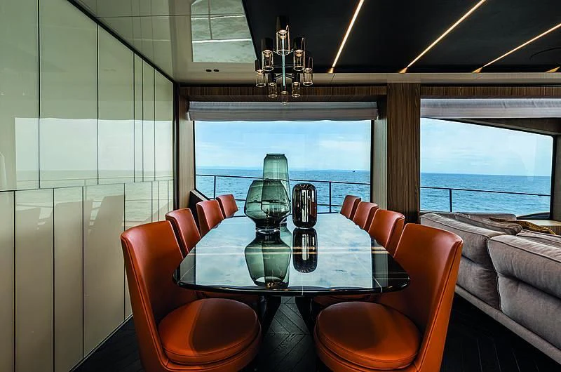 a dining table with chairs and a large window overlooking a city aboard CRANCHI SETTANTOTTO 78/01 Yacht for Sale