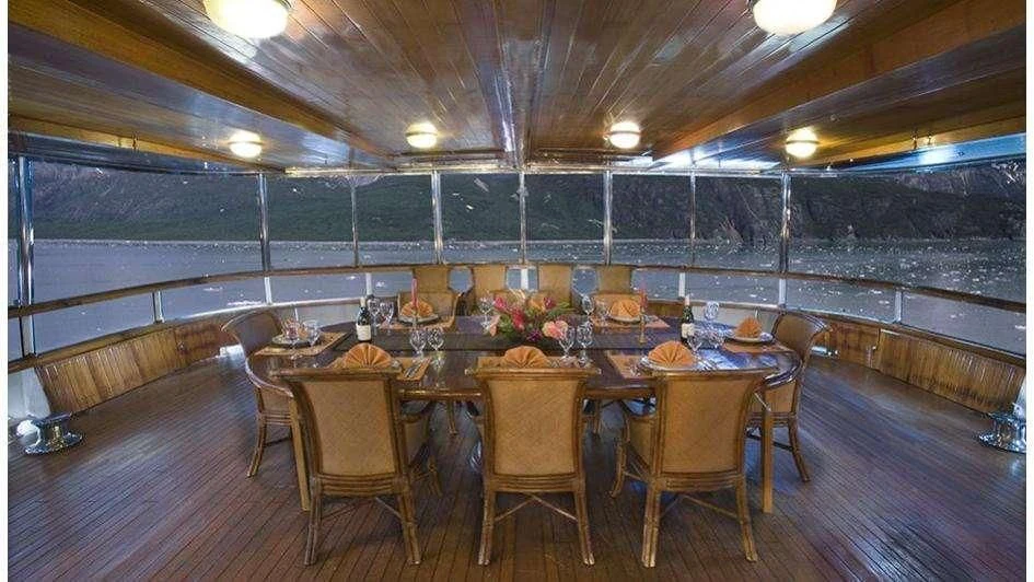 a large dining table in a room aboard STARGAZER Yacht for Sale