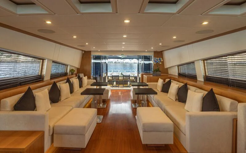 a room with couches and a table and a large window aboard LA ROMANA Yacht for Sale