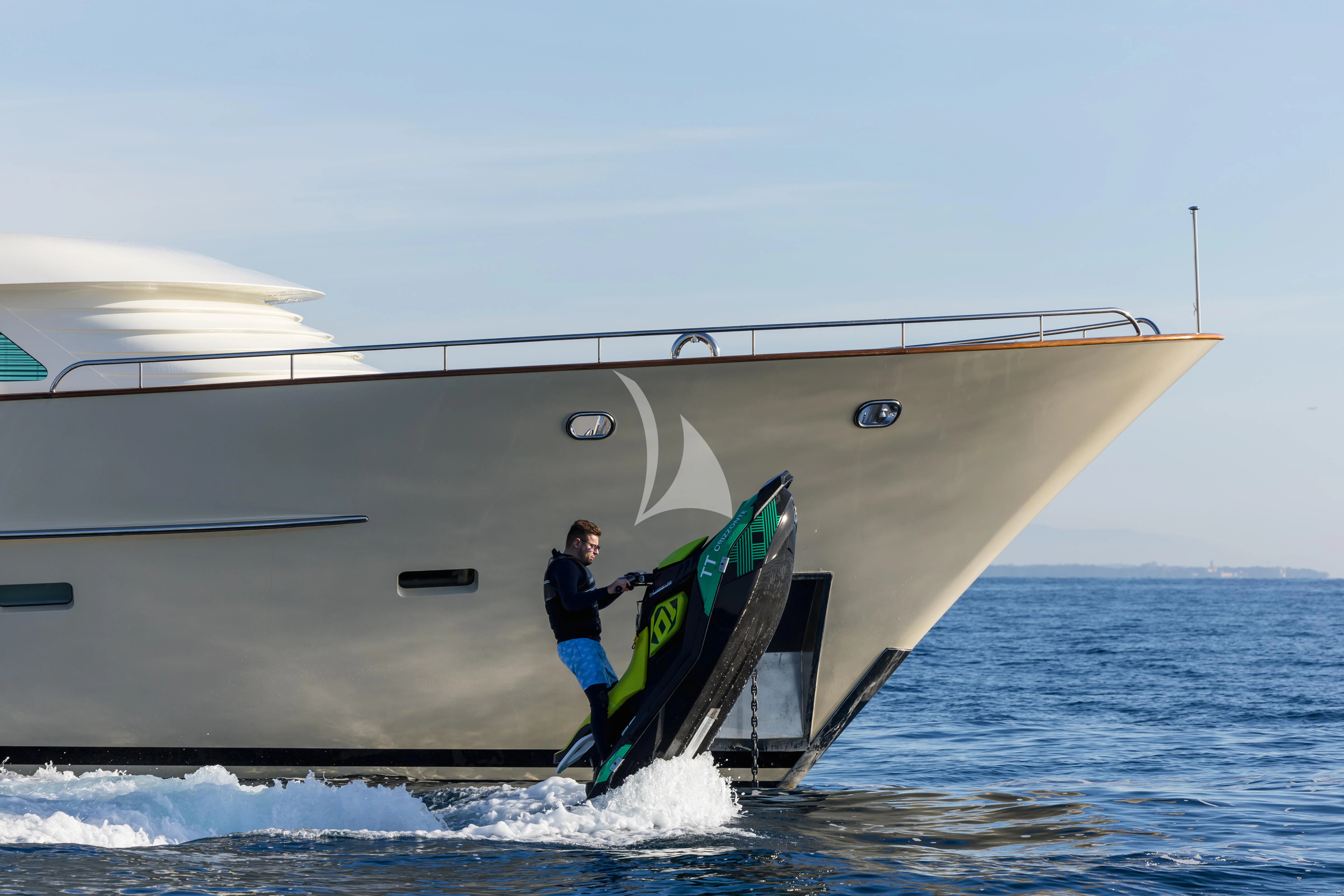 a person is holding a surfboard aboard ORIZZONTE Yacht for Sale