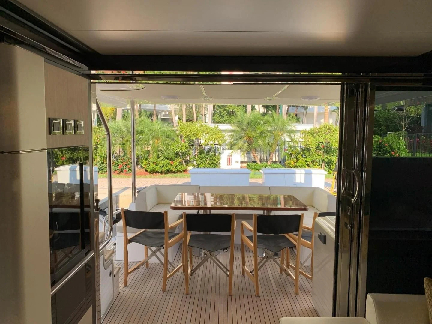 a dining table and chairs in a room with a view of the trees aboard AMALFI Yacht for Sale