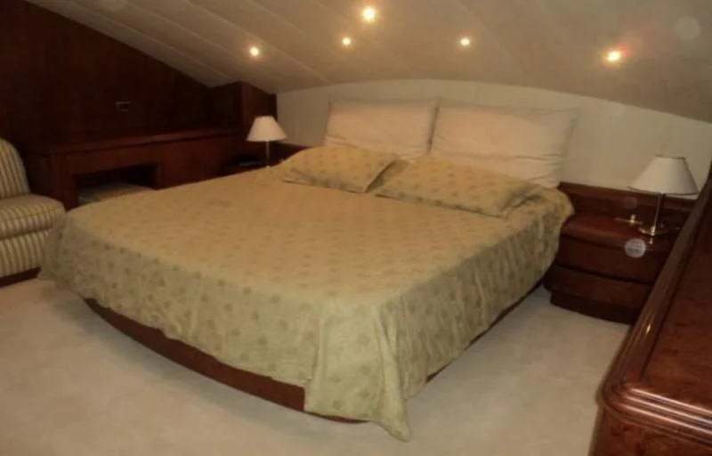 a bed with a white comforter aboard ELMAR Yacht for Sale
