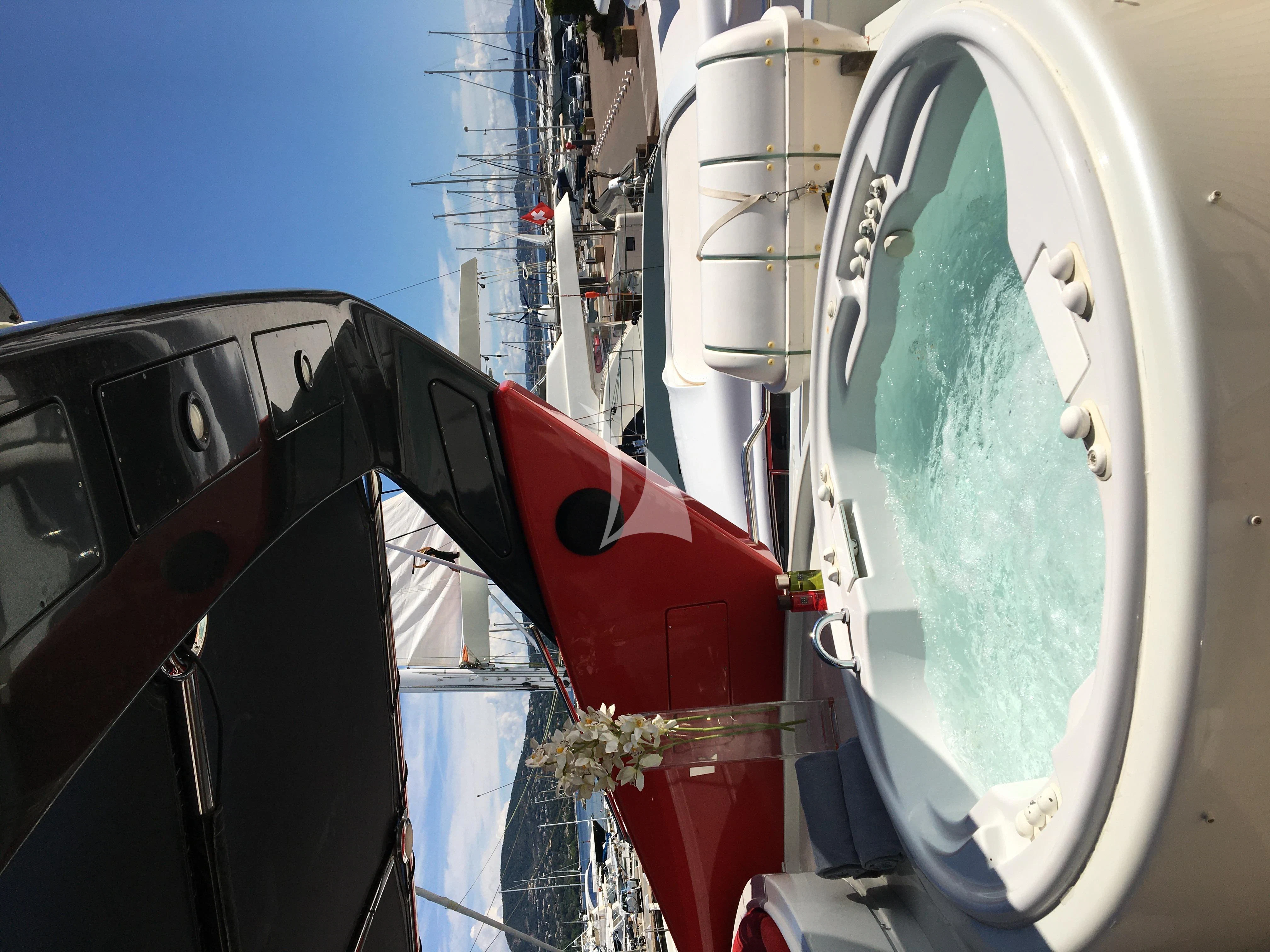 a large white boat with a red and black sail aboard FIGI Yacht for Sale