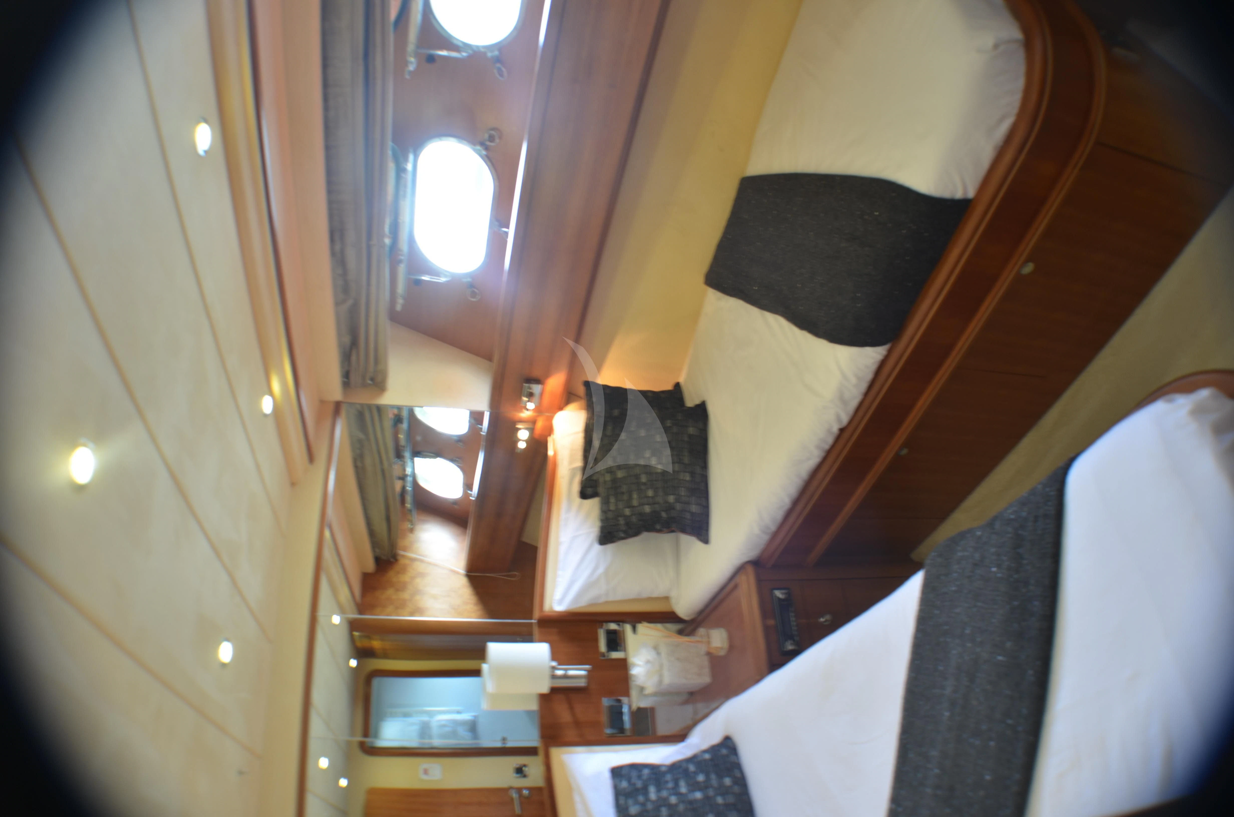 a room with a bed and a mirror aboard FIGI Yacht for Sale